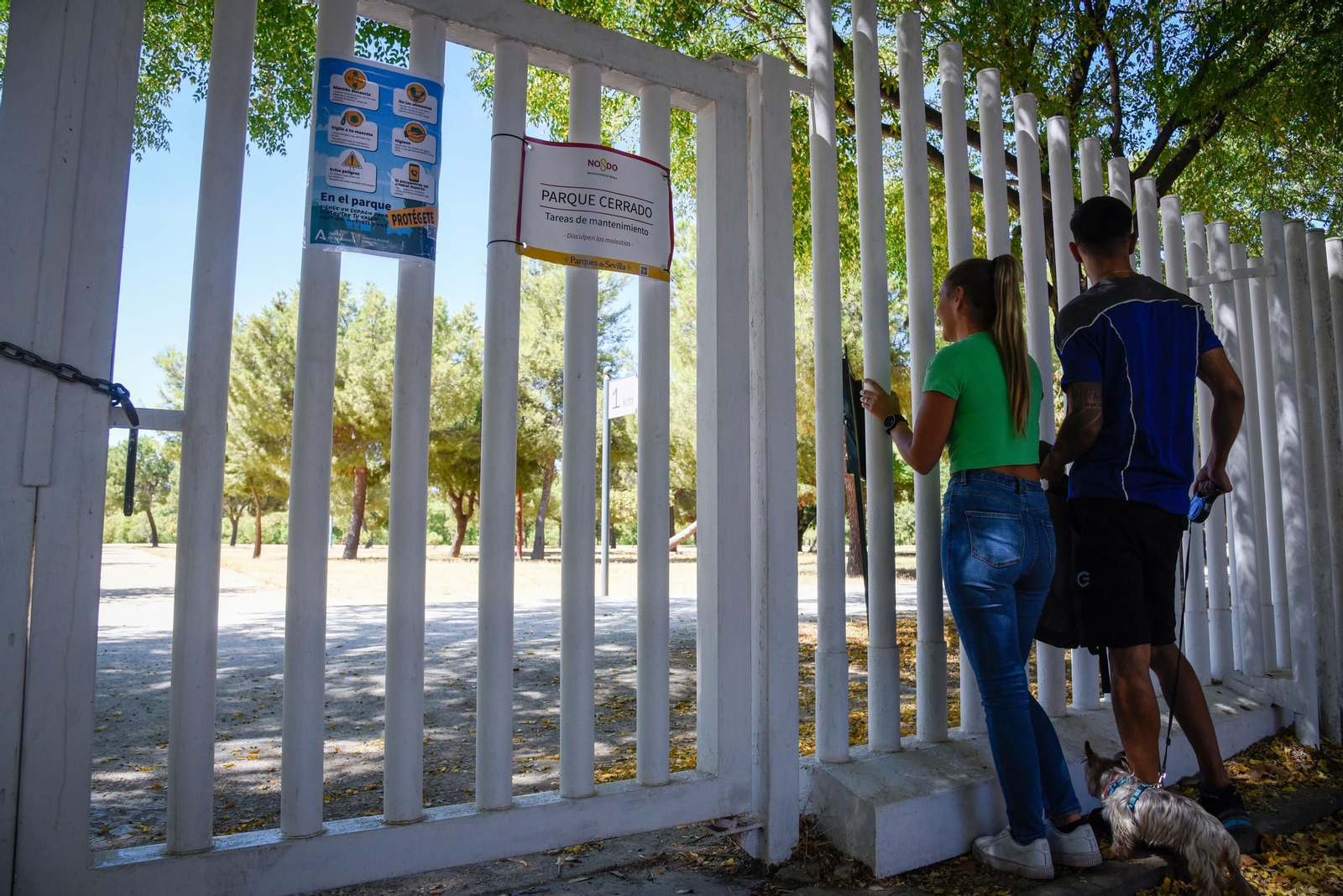 Dos personas a las puertas del Parque de Miraflores, cerrado por el brote de gripe aviar.