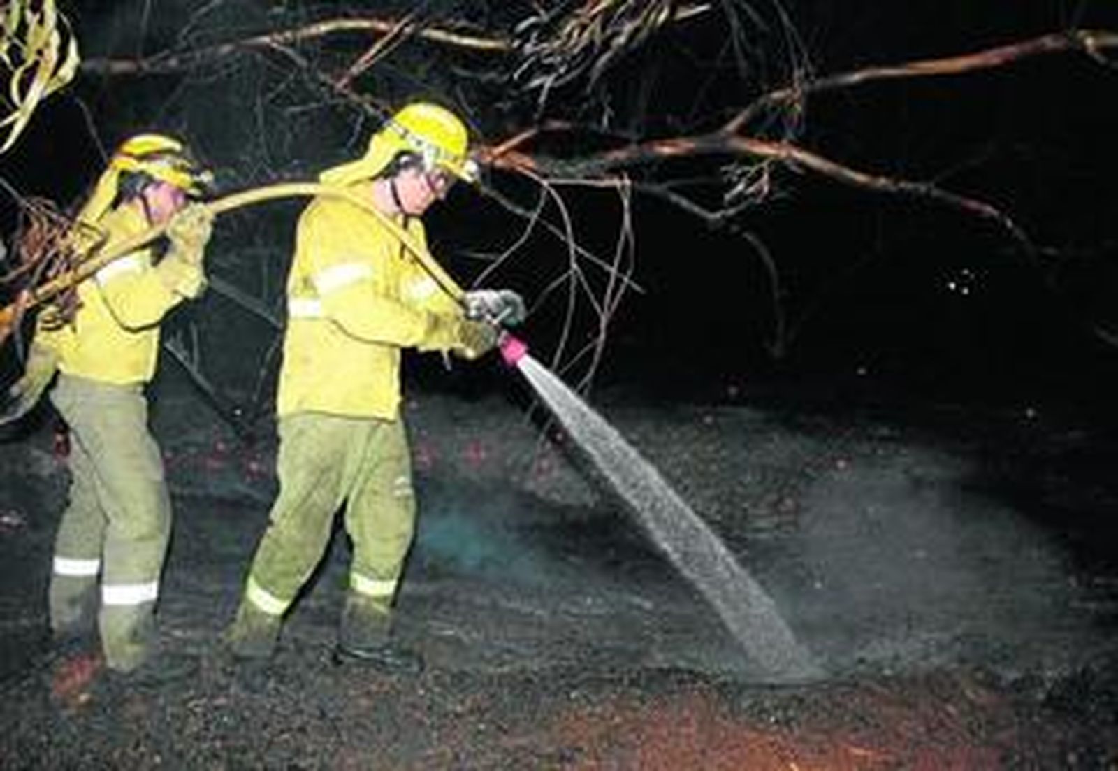 Dos bomberos, en la madrugada de ayer en la zona en la que se reactivó el fuego.