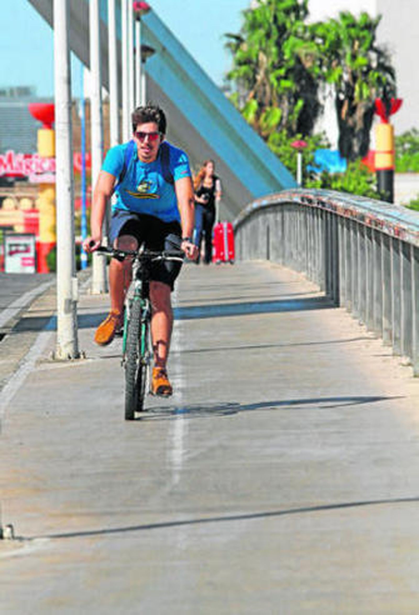 Un ciclista pasa por el puente de la Barqueta.
