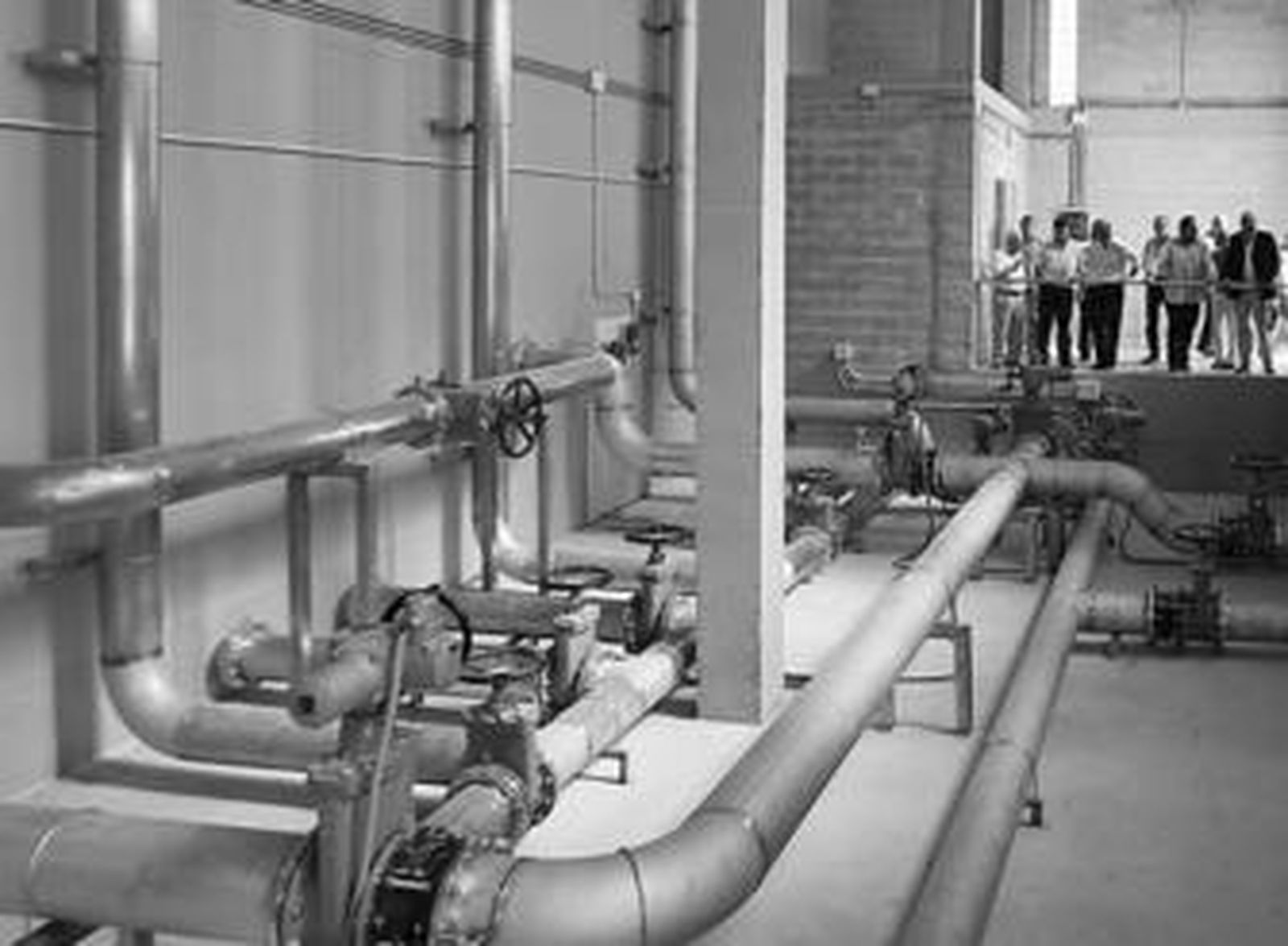 Políticos y promotores contemplan el interior del nuevo depósito.