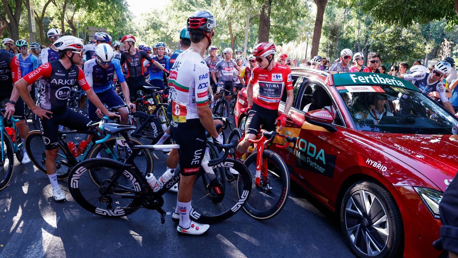Los ciclistas siendo comunicados de que la carrera finalizaba a 57 kilómetros de meta