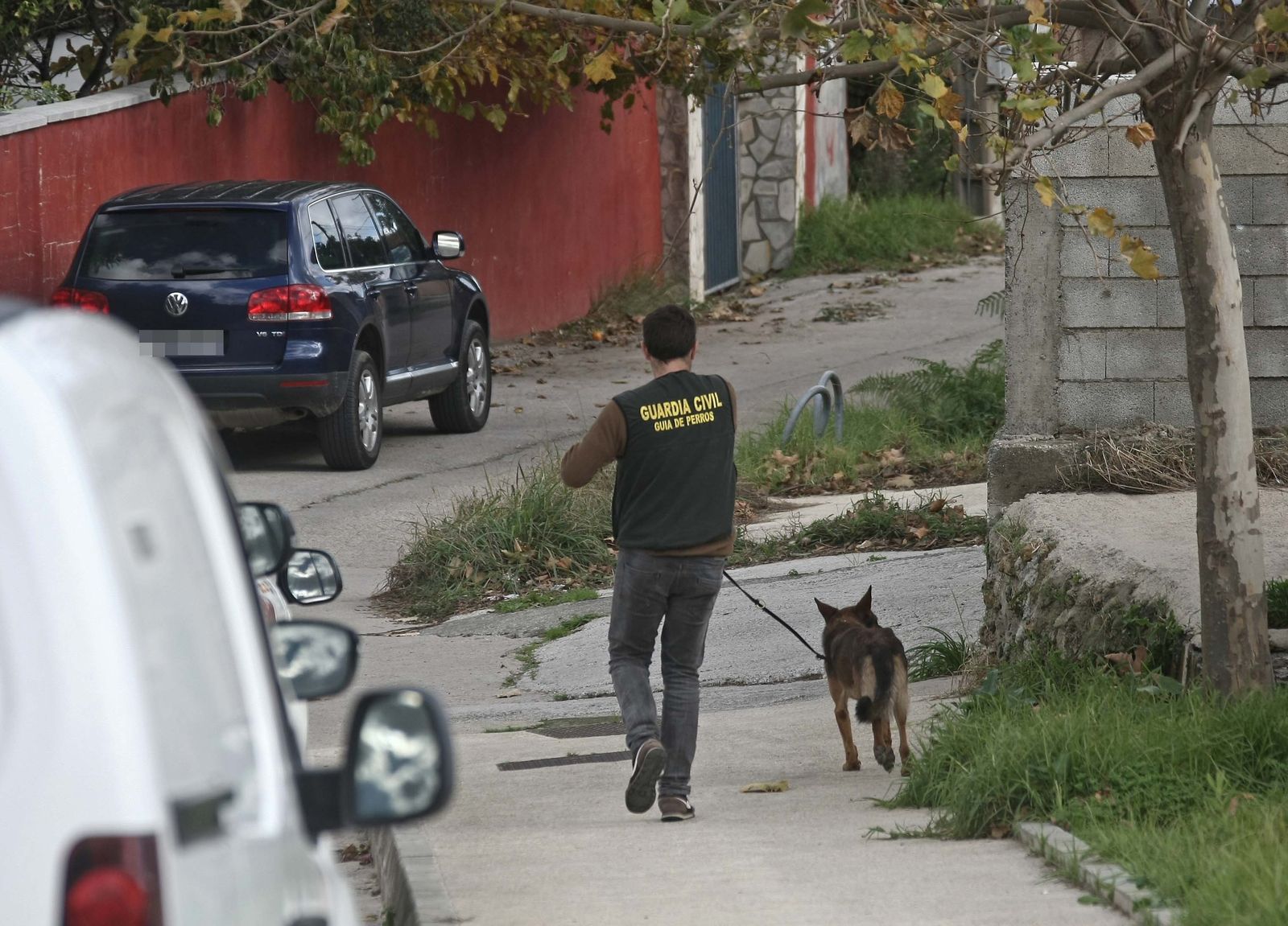 Un guardia civil camina ayer por Pelayo con un perro de detección de droga.