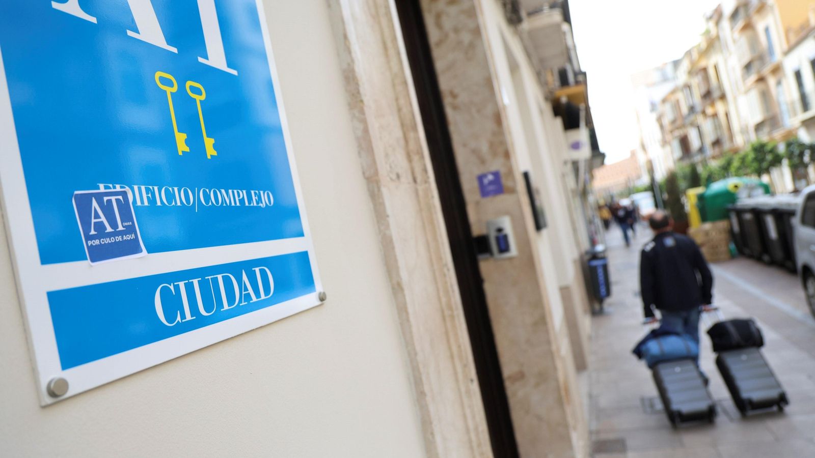 Un turista pasa frente a un apartamento al que le han colocado una pegatina