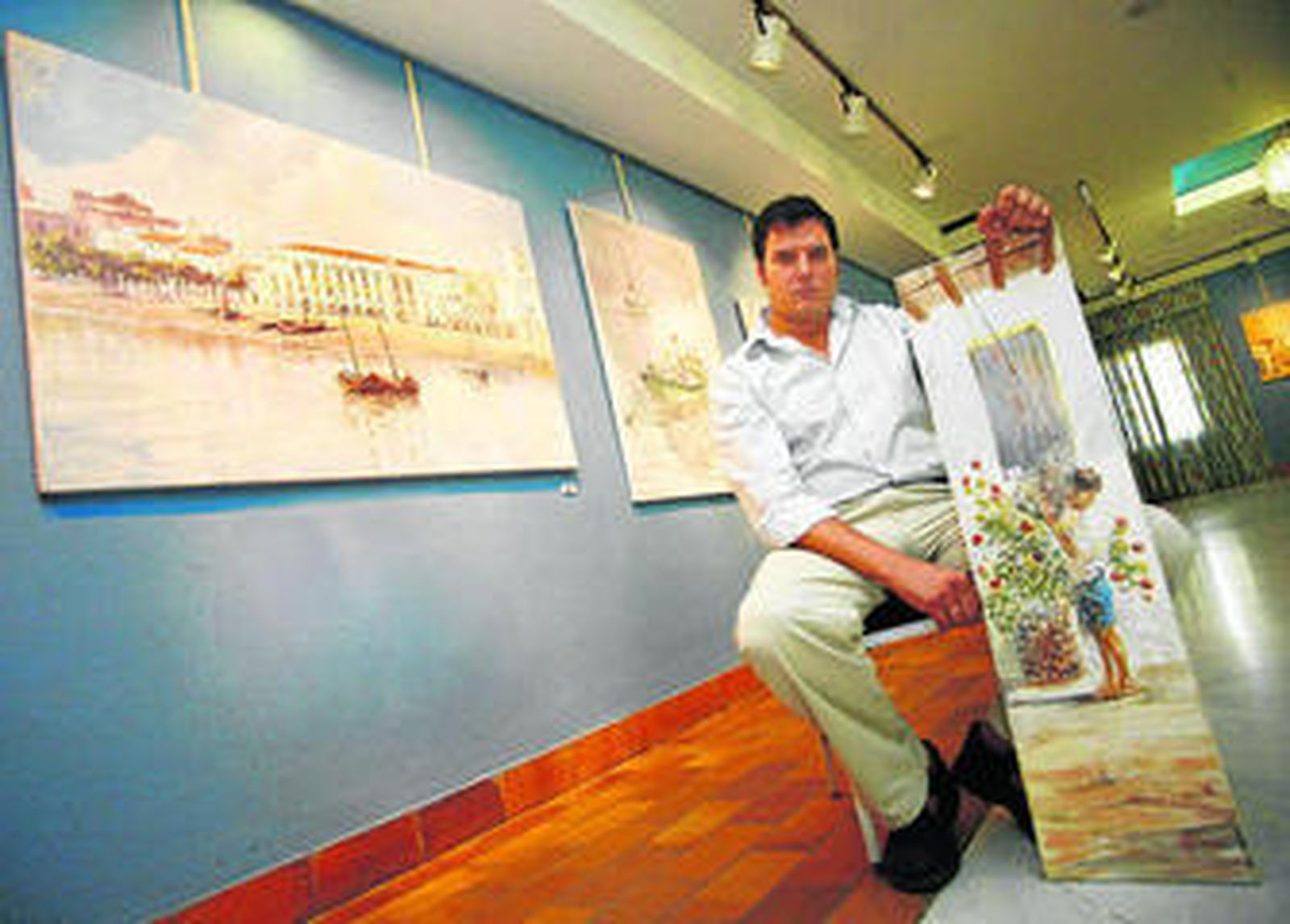 Una imagen del pintor durante una de sus anteriores exposiciones mostrando algunas de sus obras costumbristas.