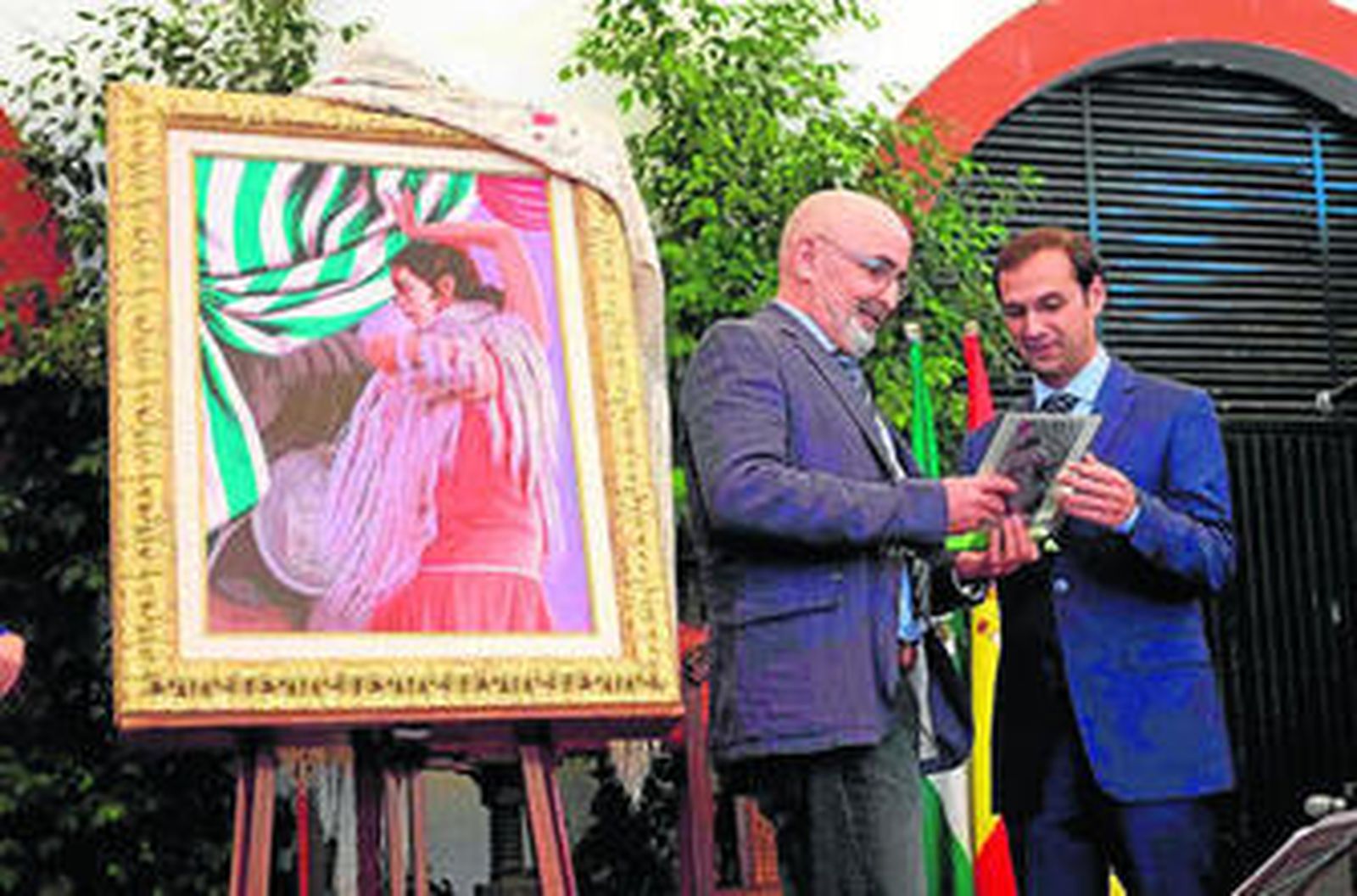 El alcalde felicitando al autor del cartel anunciador en el acto público de presentación de la Feria.