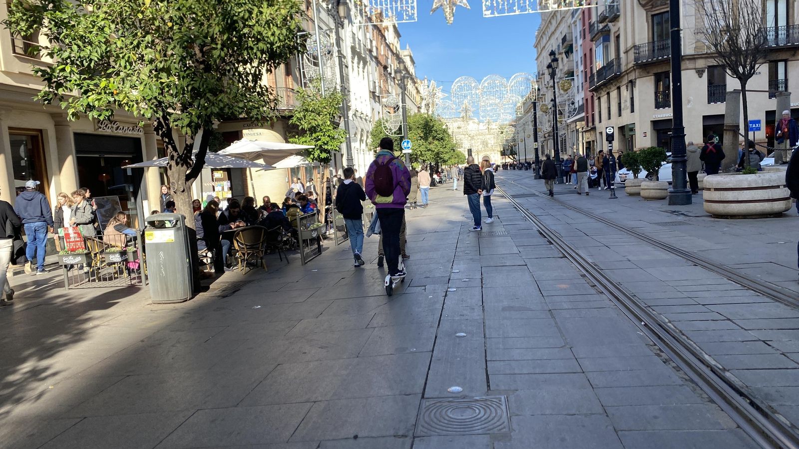 Un hombre montado en el patinete en la Avenida de la Constitución