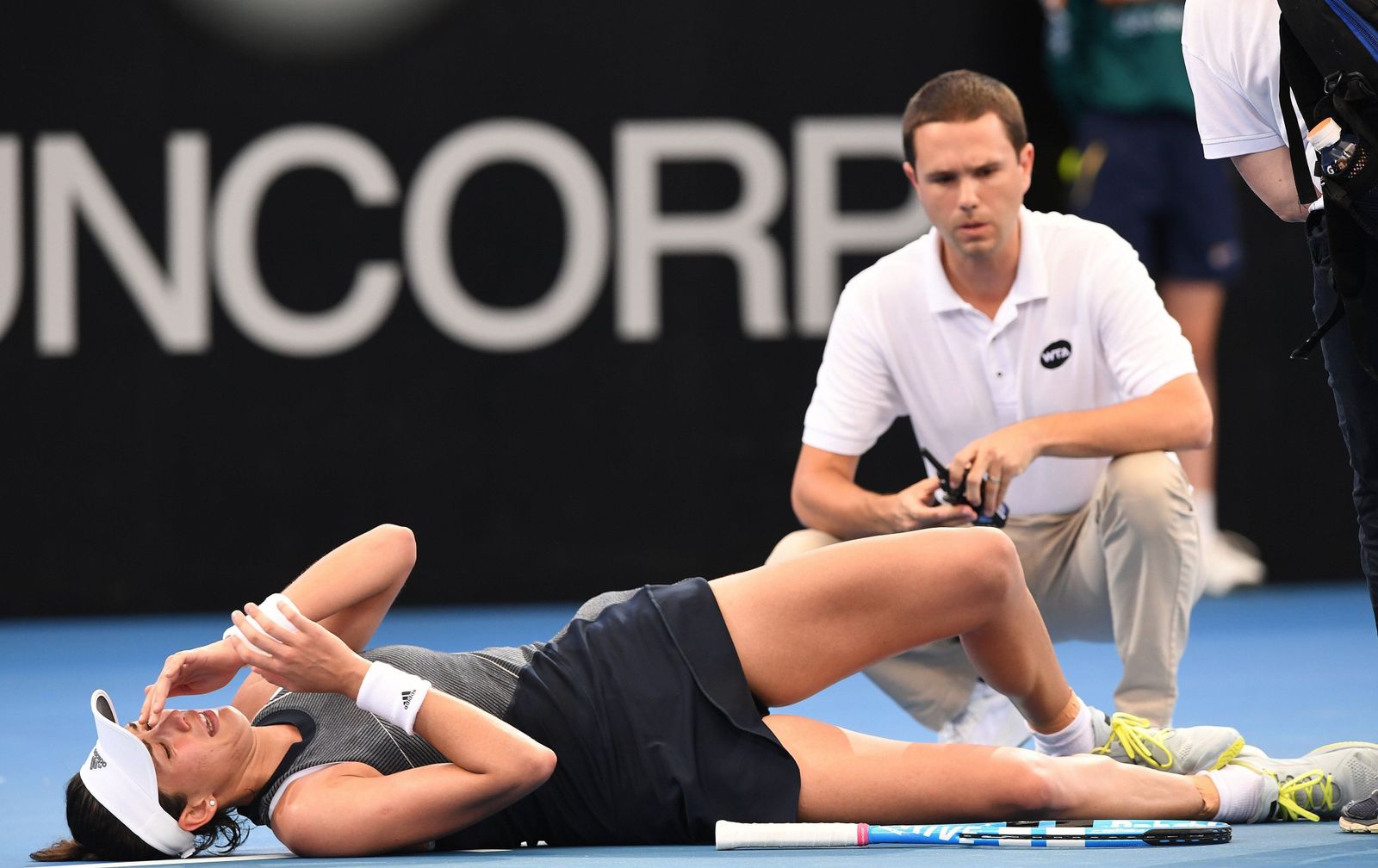 Garbiñe Muguruza se duele de los calambres sobre la pista mientras se enfrentaba a Aleksandra Krunica en la primera ronda del torneo de Brisbane.
