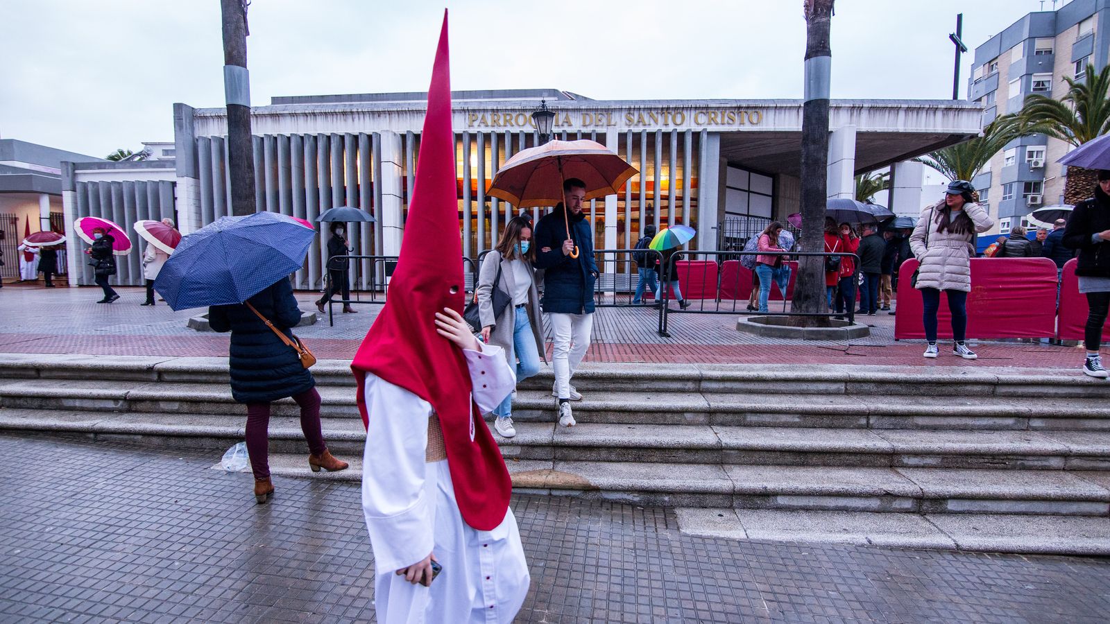 Un hermano de Afligidos se dirige hacia su casa de vuelta tras suspenderse la salida procesional.