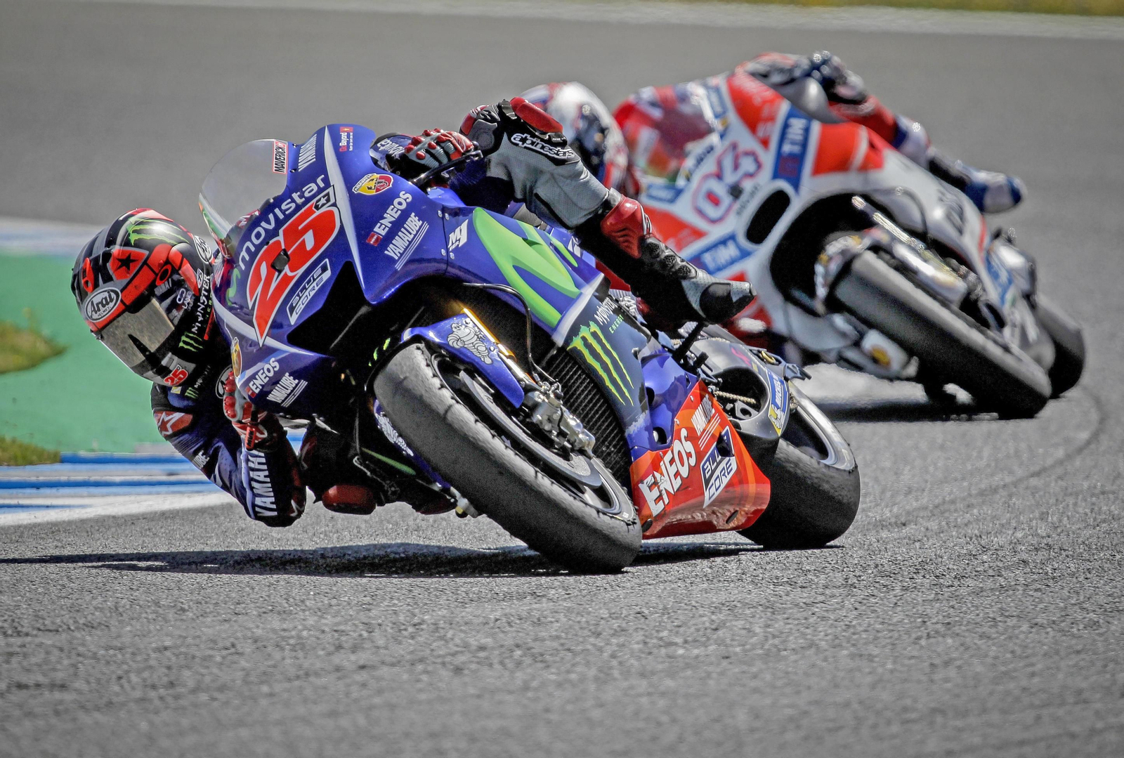 Maverick Viñales, tumbando la Yamaha en los entrenamientos de ayer con la Ducati de Andrea Dovizioso a rebufo a la salida de la curva Ángel Nieto.