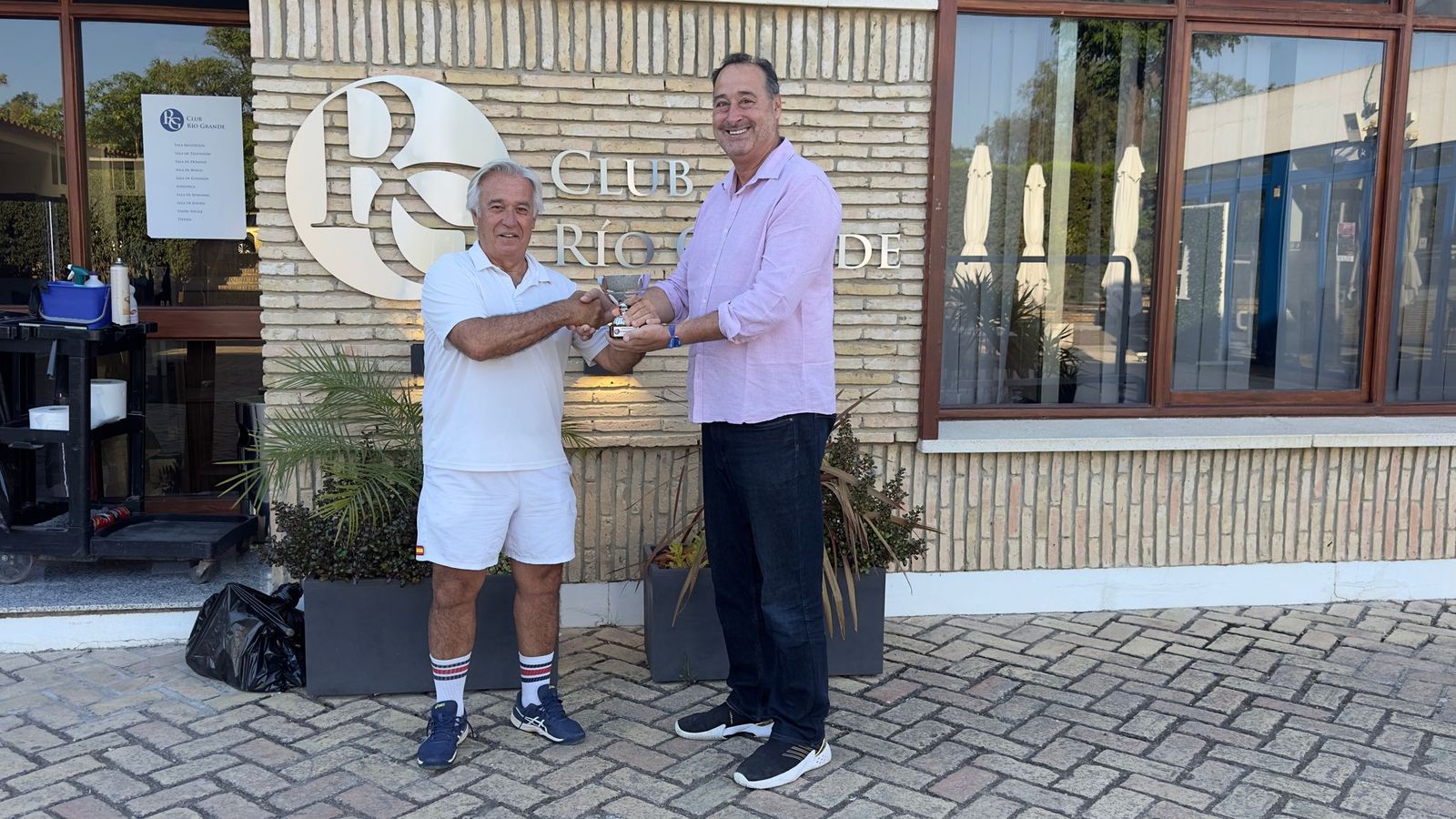 Julio Rodríguez, director y juez árbitro del torneo, entrega la copa de campeón al jerezano Ramón Romero Abad.