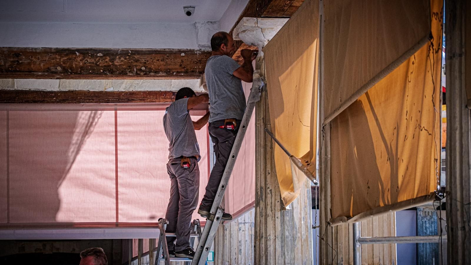 Trabajadores de Toldos Guerra, colocando uno de los nuevos paños que sustituyen a los antiguos.