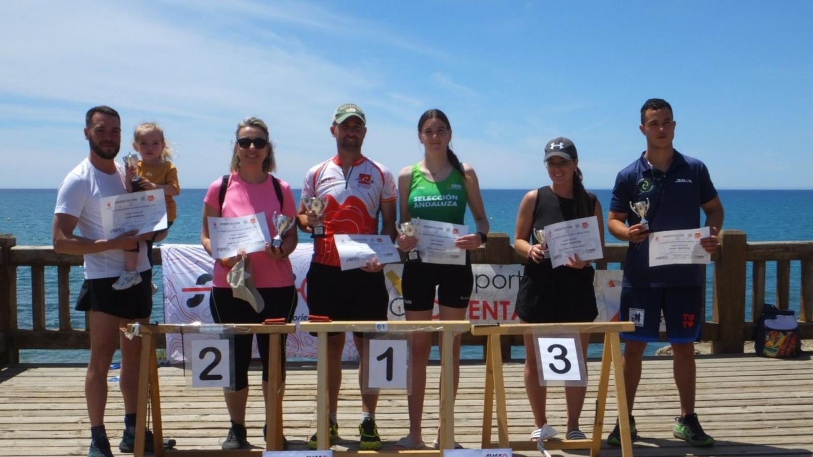 Varios de los participantes en estos Juegos Deportivos Municipales recogen sus respectivos trofeos.