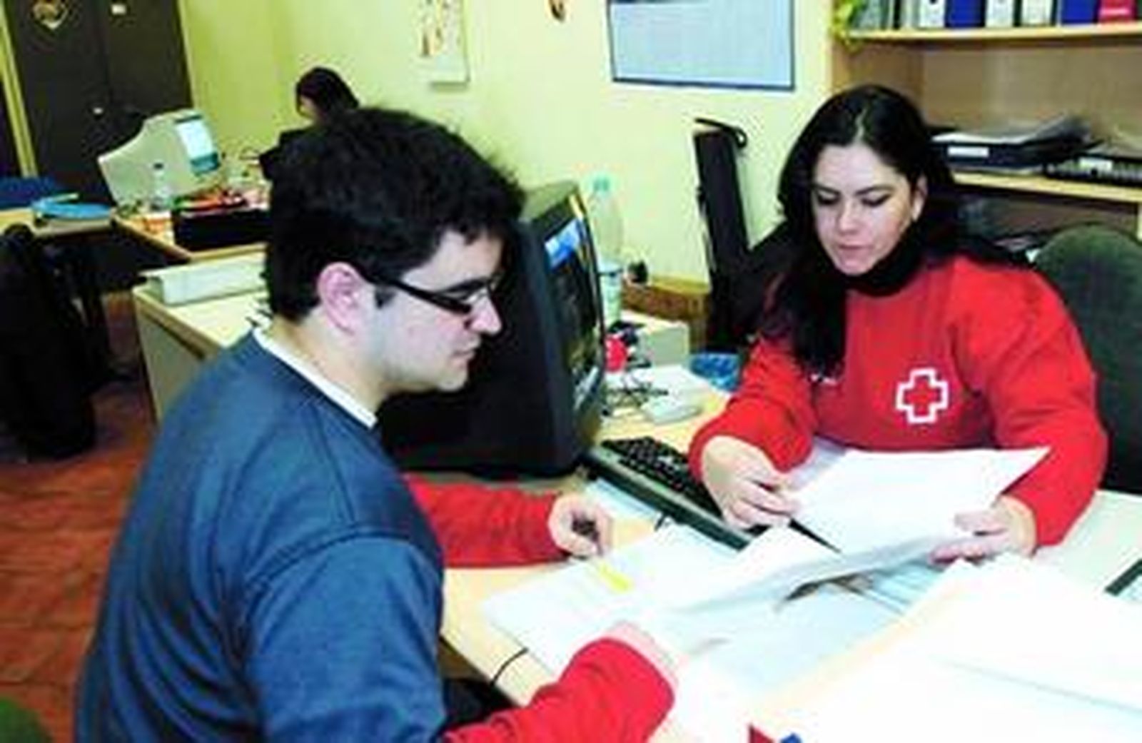 Pilar Martínez atiende a un usuario en la sede de Cruz Roja.