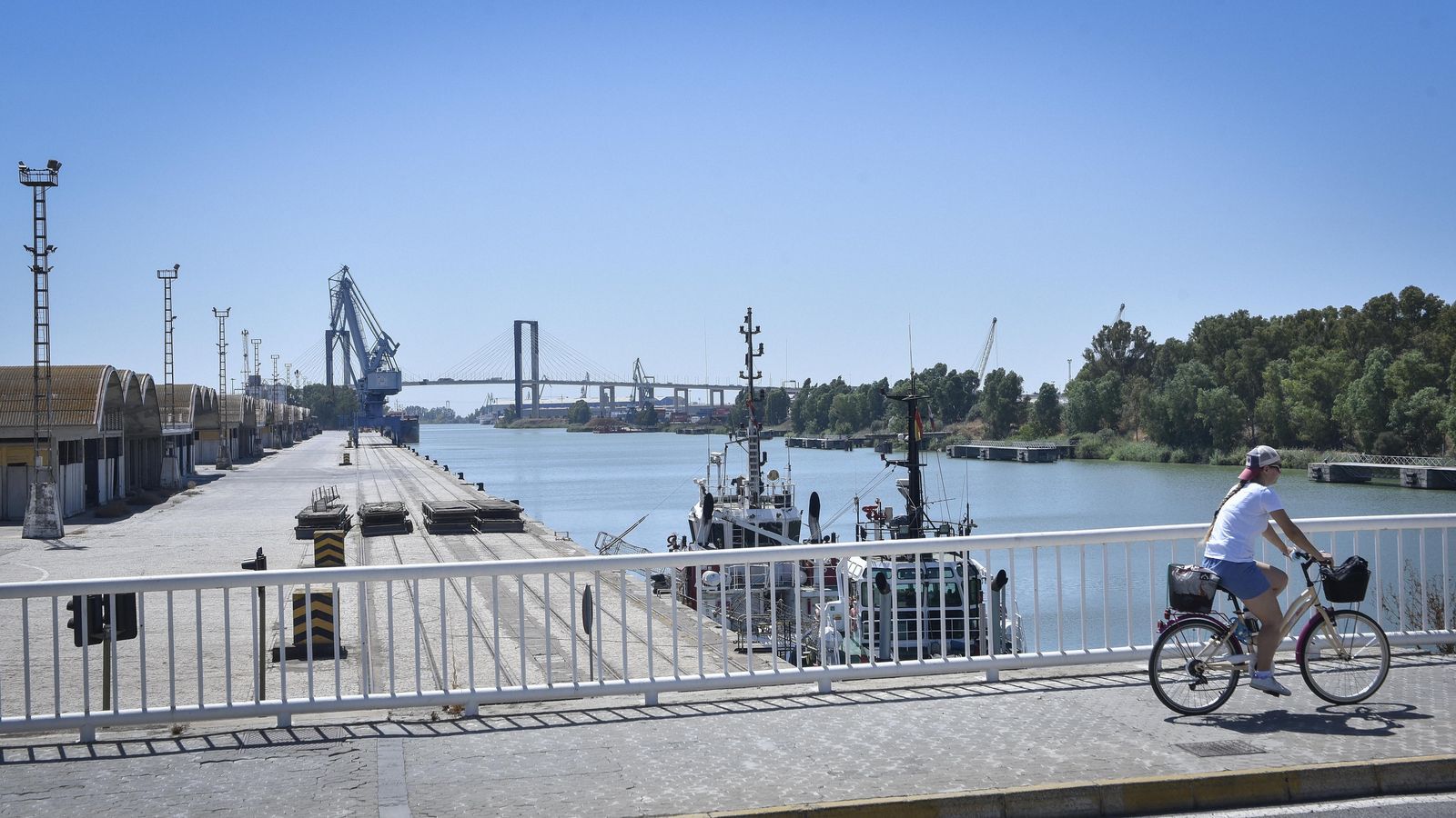 Una mujer circula en bicicleta por el puente de las Delicias.