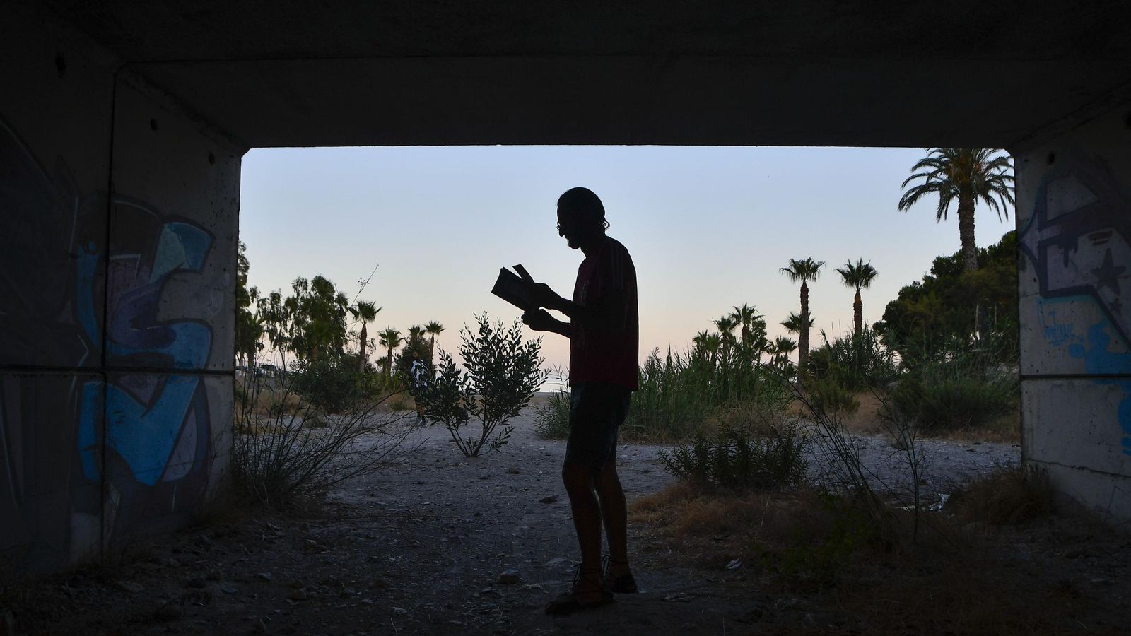La silueta de Miguel bajo el puente donde vive.