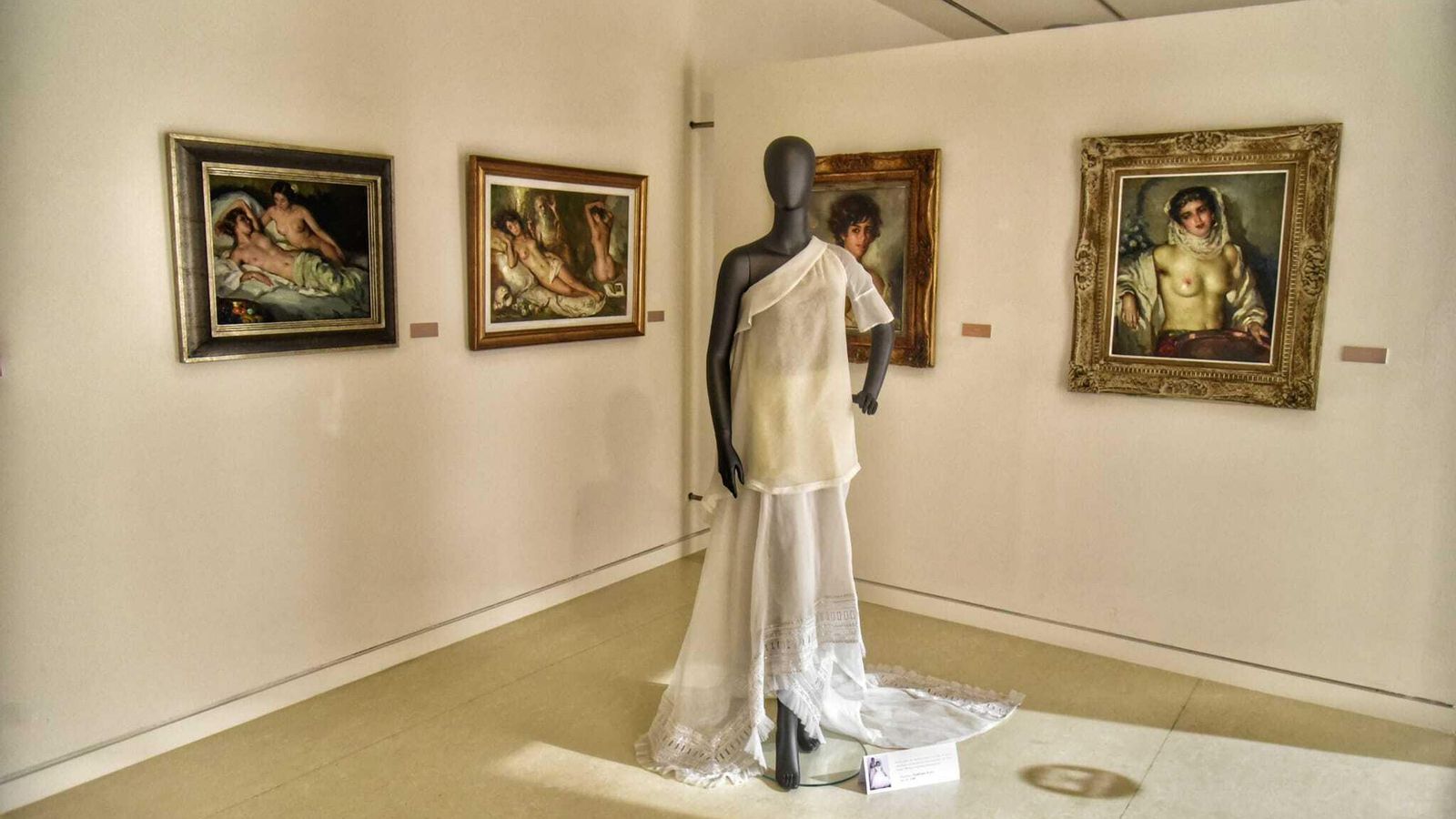 Pieza de alta costura y, de fondo, desnudos femeninos de Cruz Herrera.