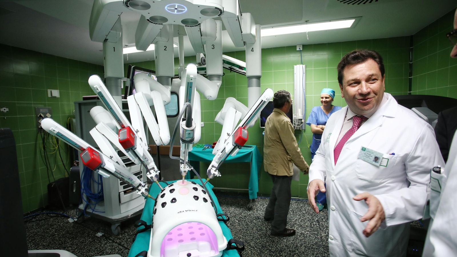 El gerente del hospital junto al sistema robótico Da Vinci en el quirófano que se está usando para la formación.
