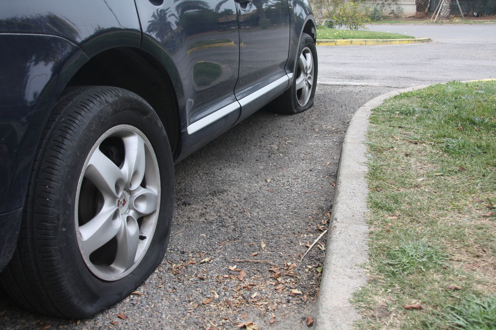 Uno de los vehículos afectados todavía seguía este lunes en la calle con los neumáticos pinchados