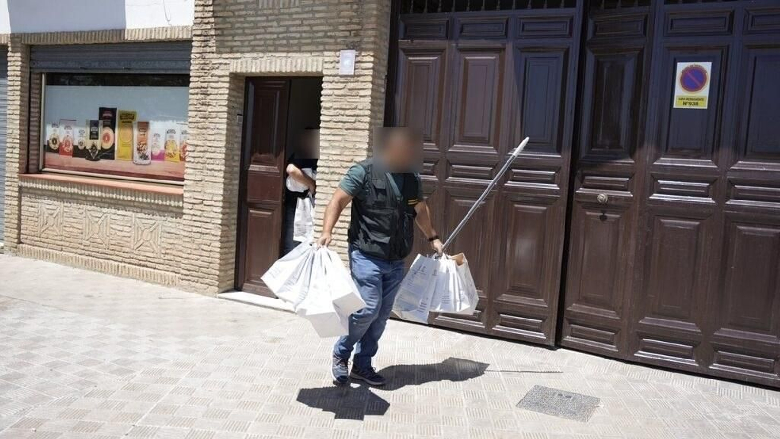 Agentes de la Guardia Civil salen de la vivienda donde fue localizado el cadáver en Utrera.