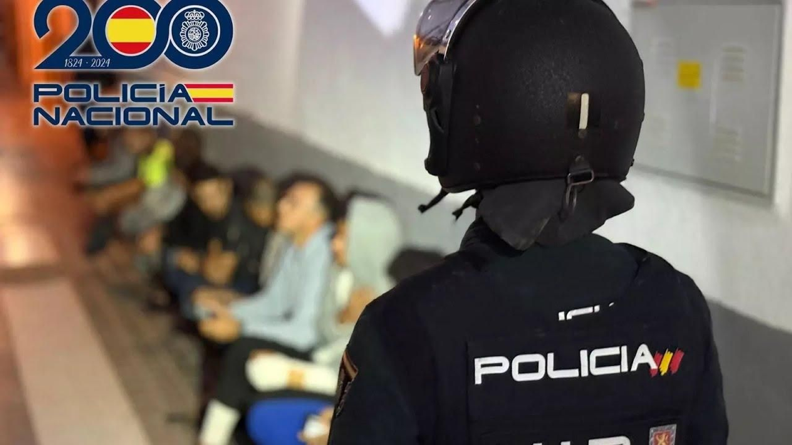 Un agente custodia a parte de los detenidos en la operación.