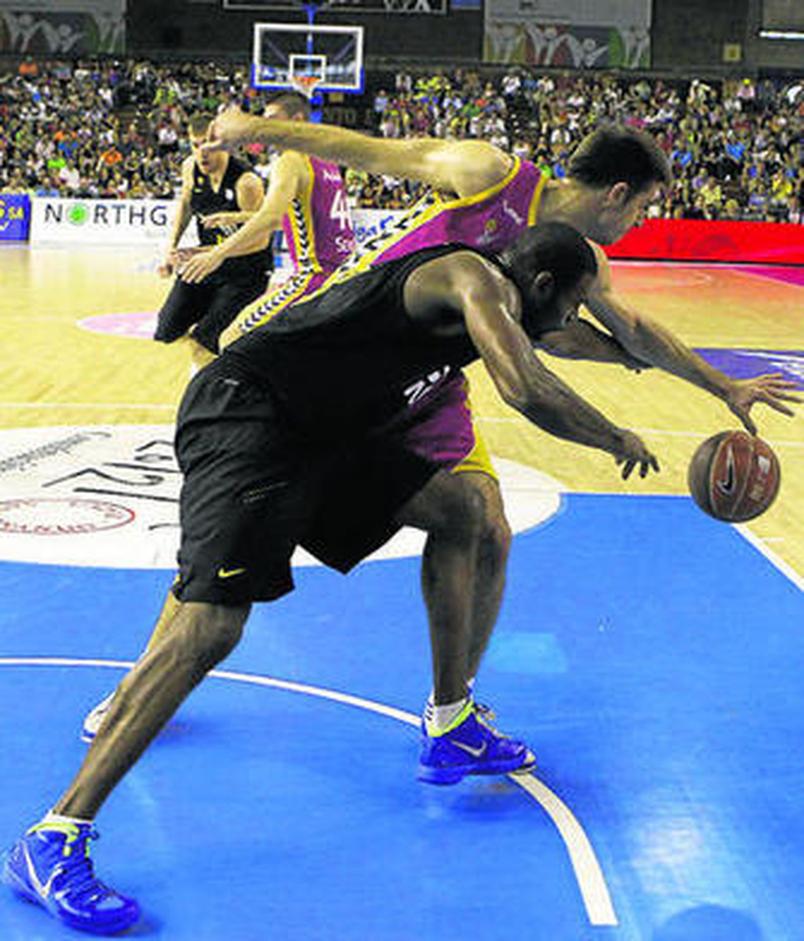 Pete Mickeal, en primer término, luchando por el balón con Paul Davis.