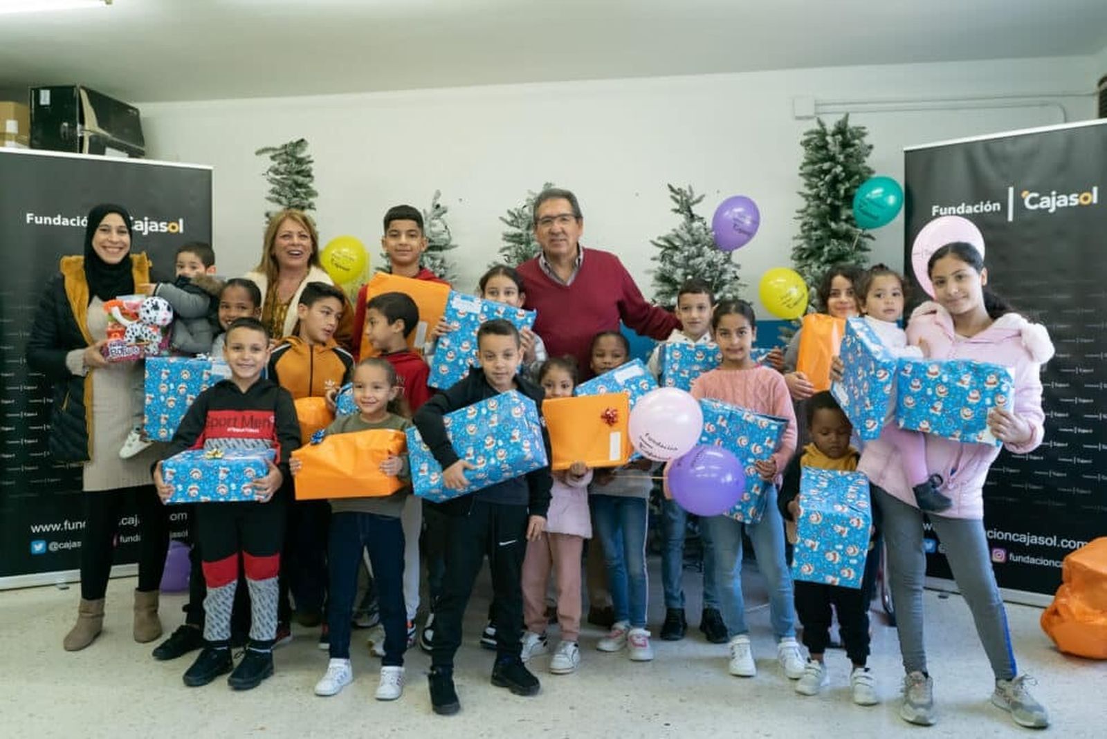 Antonio Pulido, presidente de la Fundación Cajasol, entregando juguetes a los niños de la ONG Cooperación Internacional.