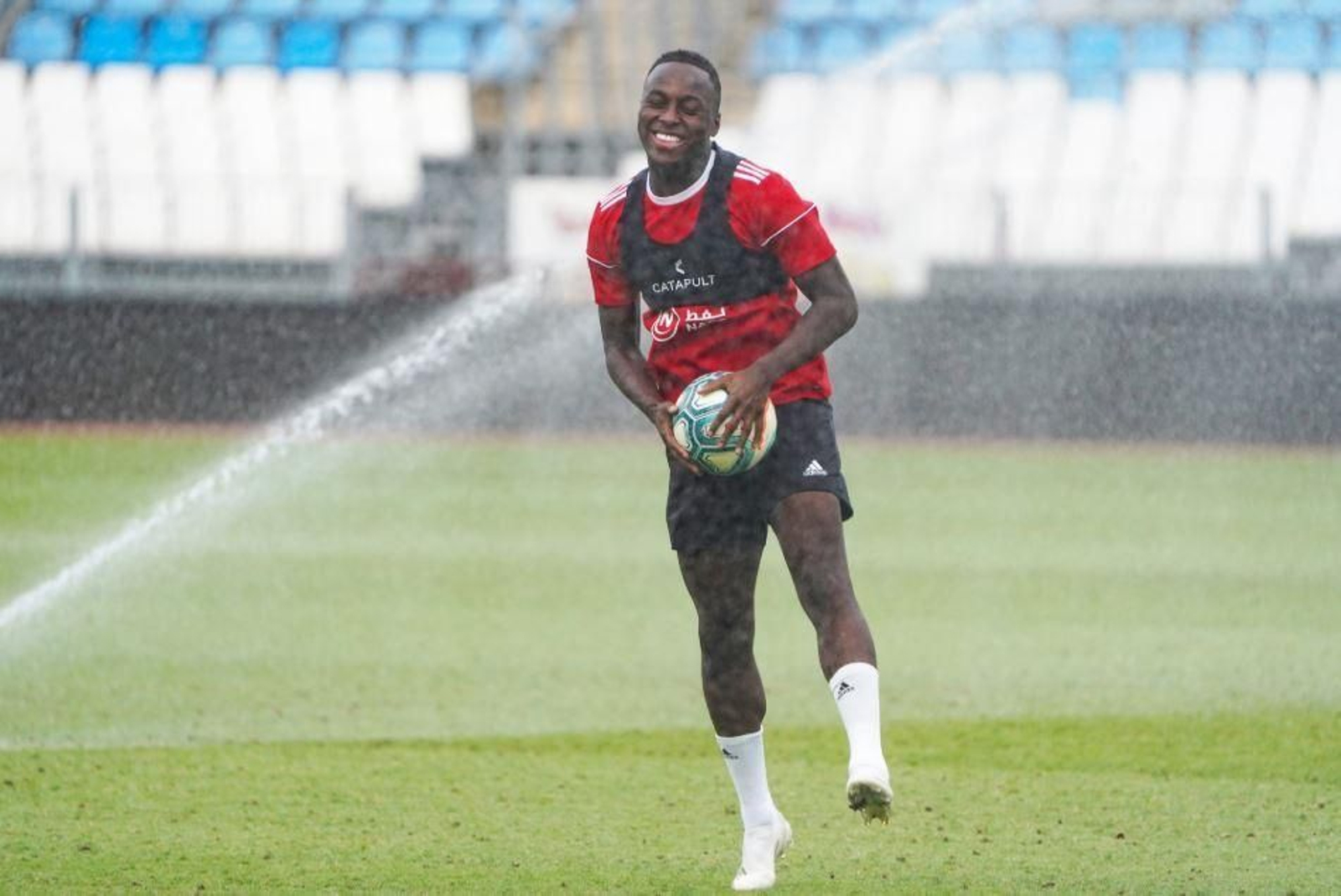 Appiah se refresca con el agua de los aspersores.