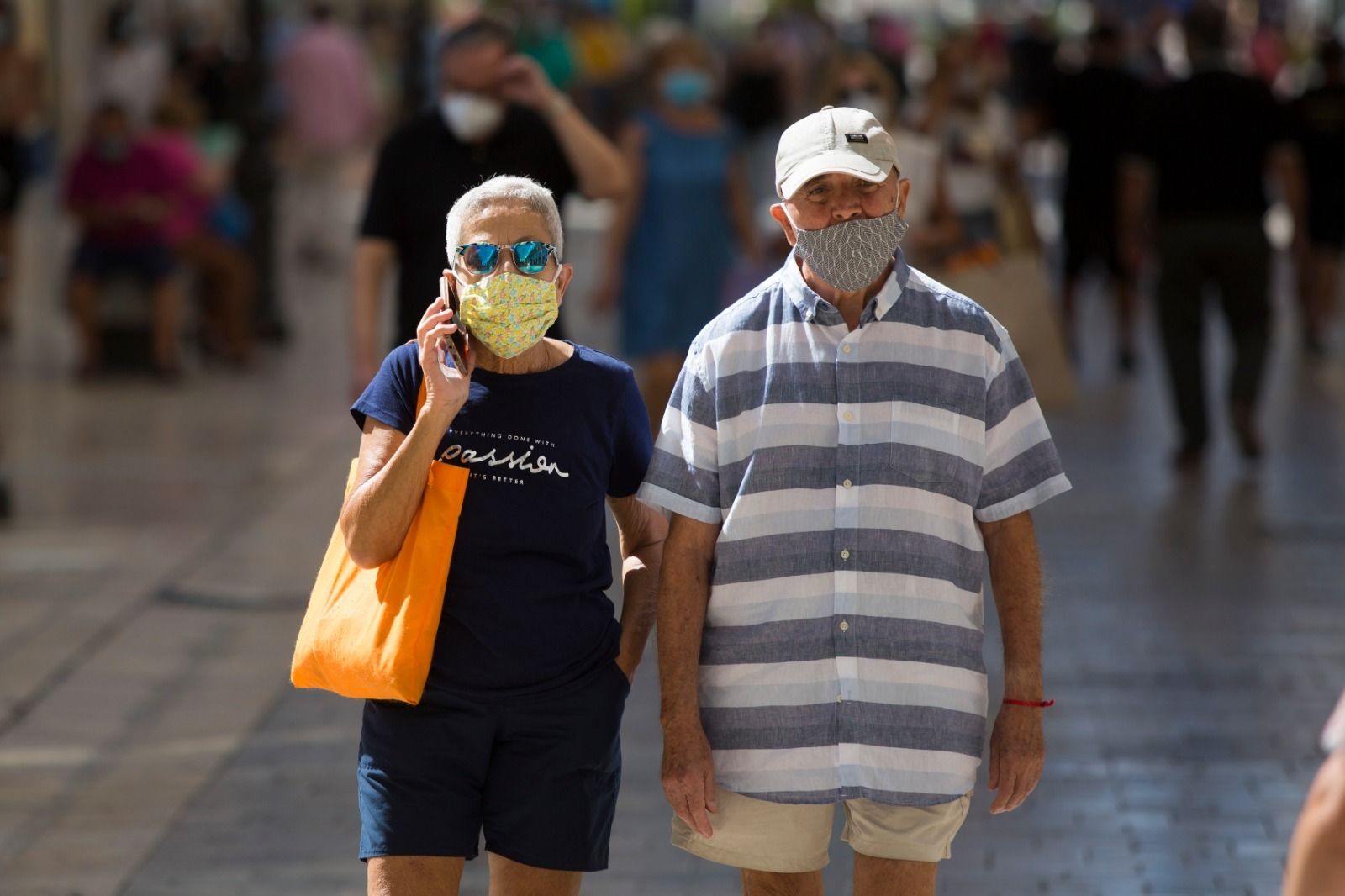 Una pareja camina por la calle Larios de Málaga.