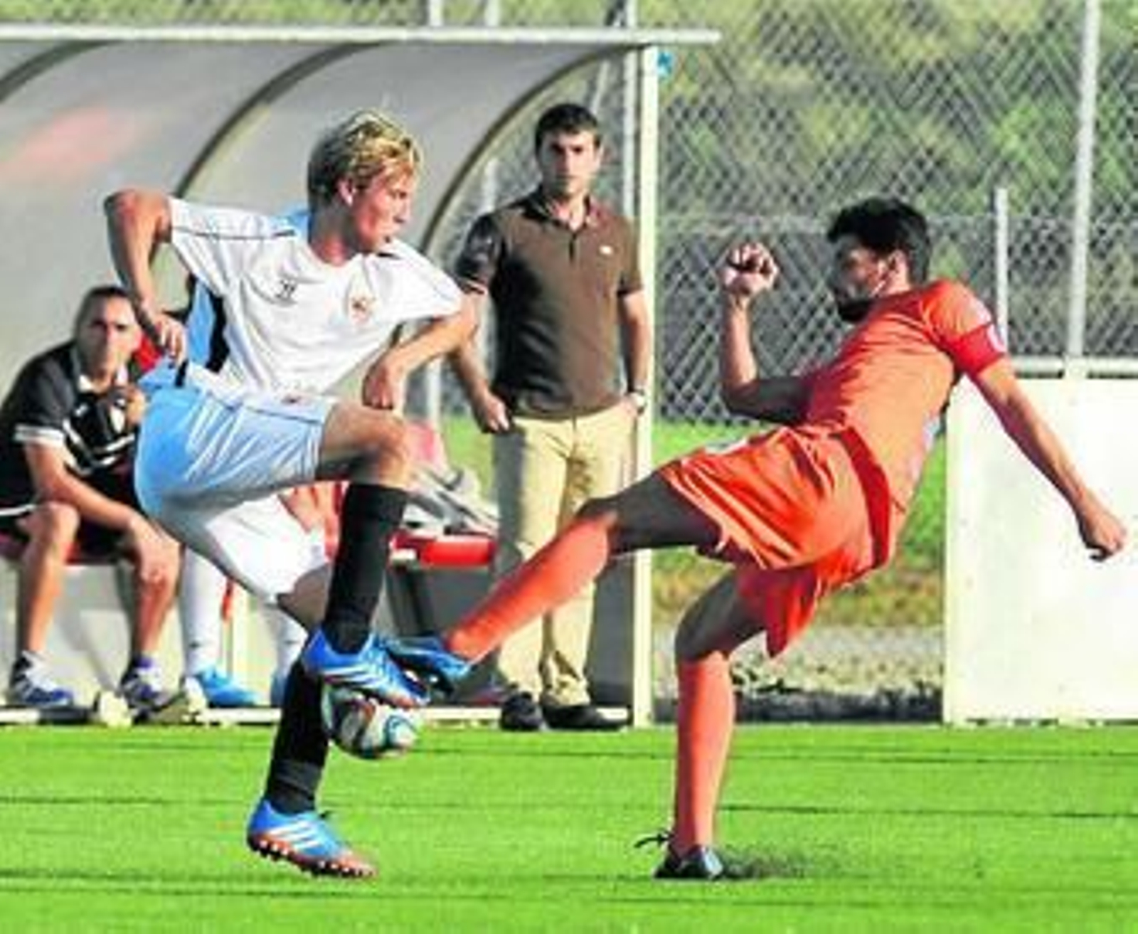 Bugatto trata de controlar el balón ante la oposición de un rival.