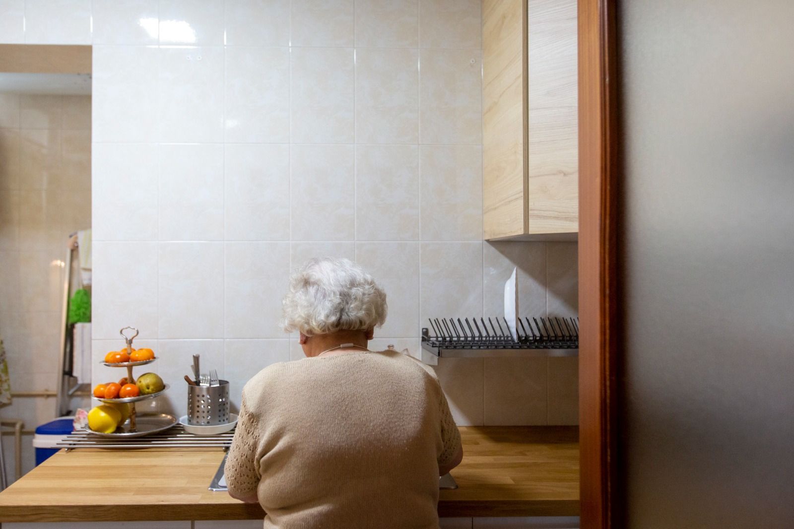 Una anciana en la cocina de su vivienda.