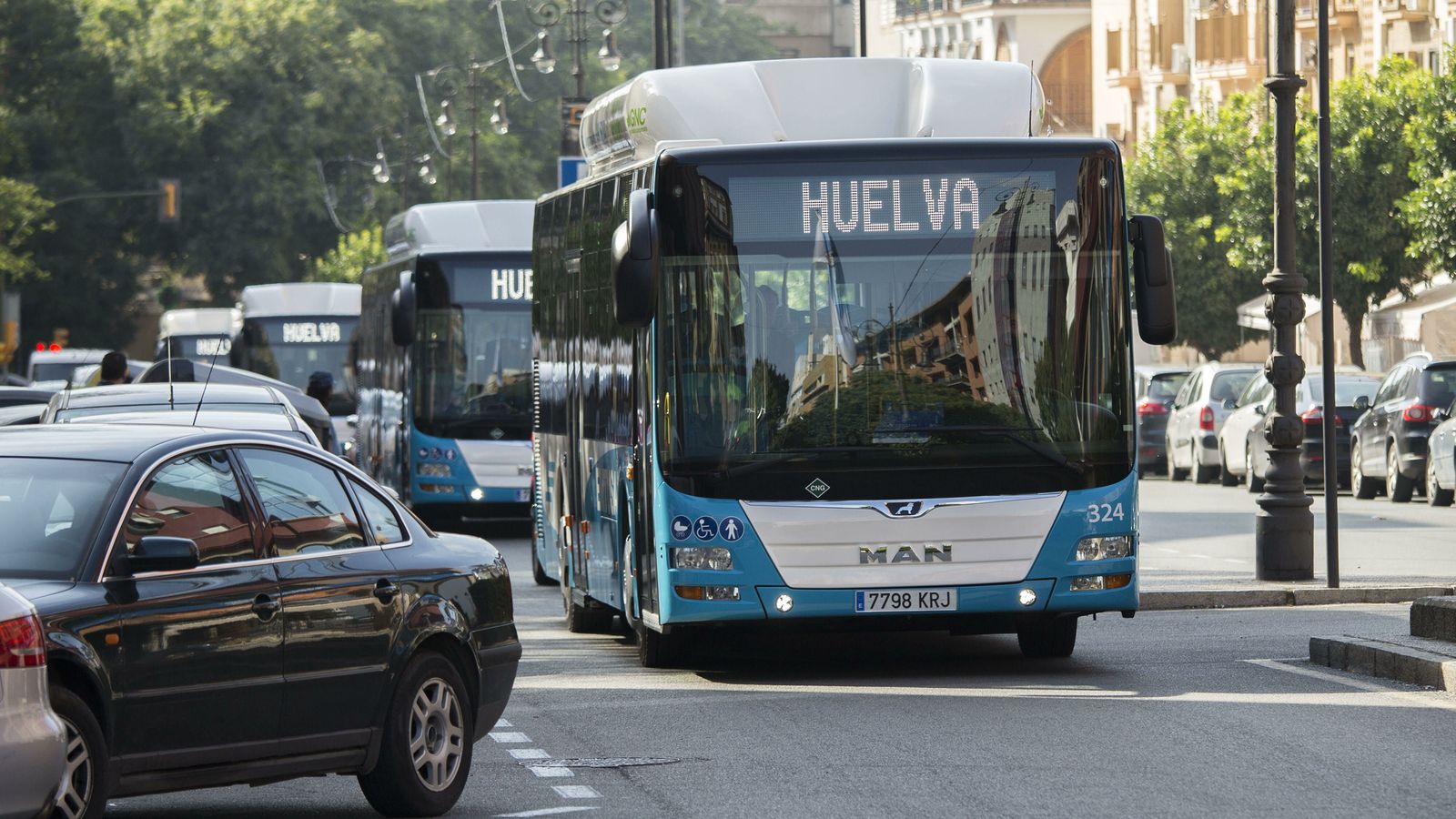 Varios autocares avanzan por las calles de Huelva.