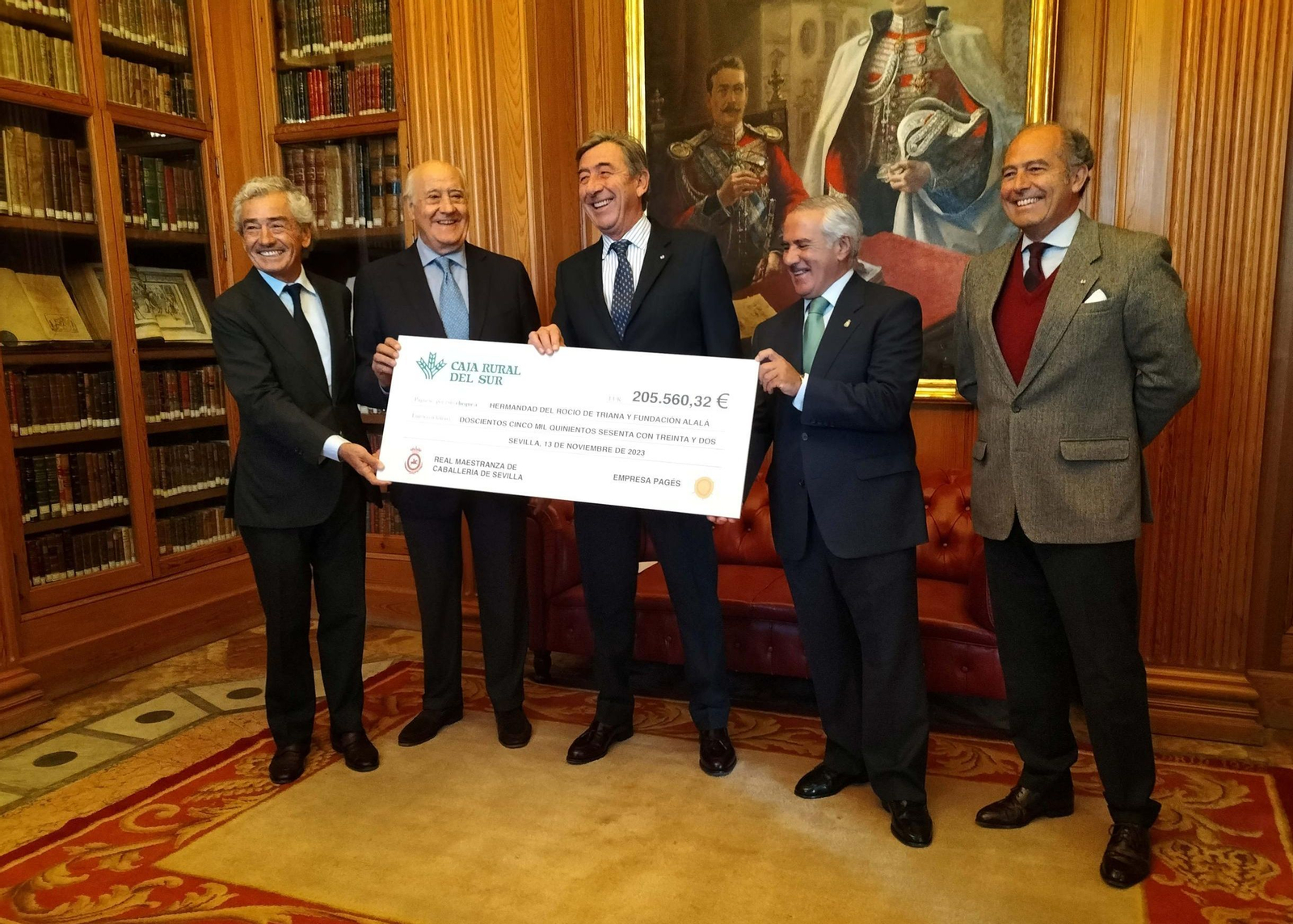 Pacheco Guardiola, a la izquierda, en la entrega del cheque del festival de 2023 junto a Ramón Valencia y el anterior teniente de Hermano Mayor, Santiago León.