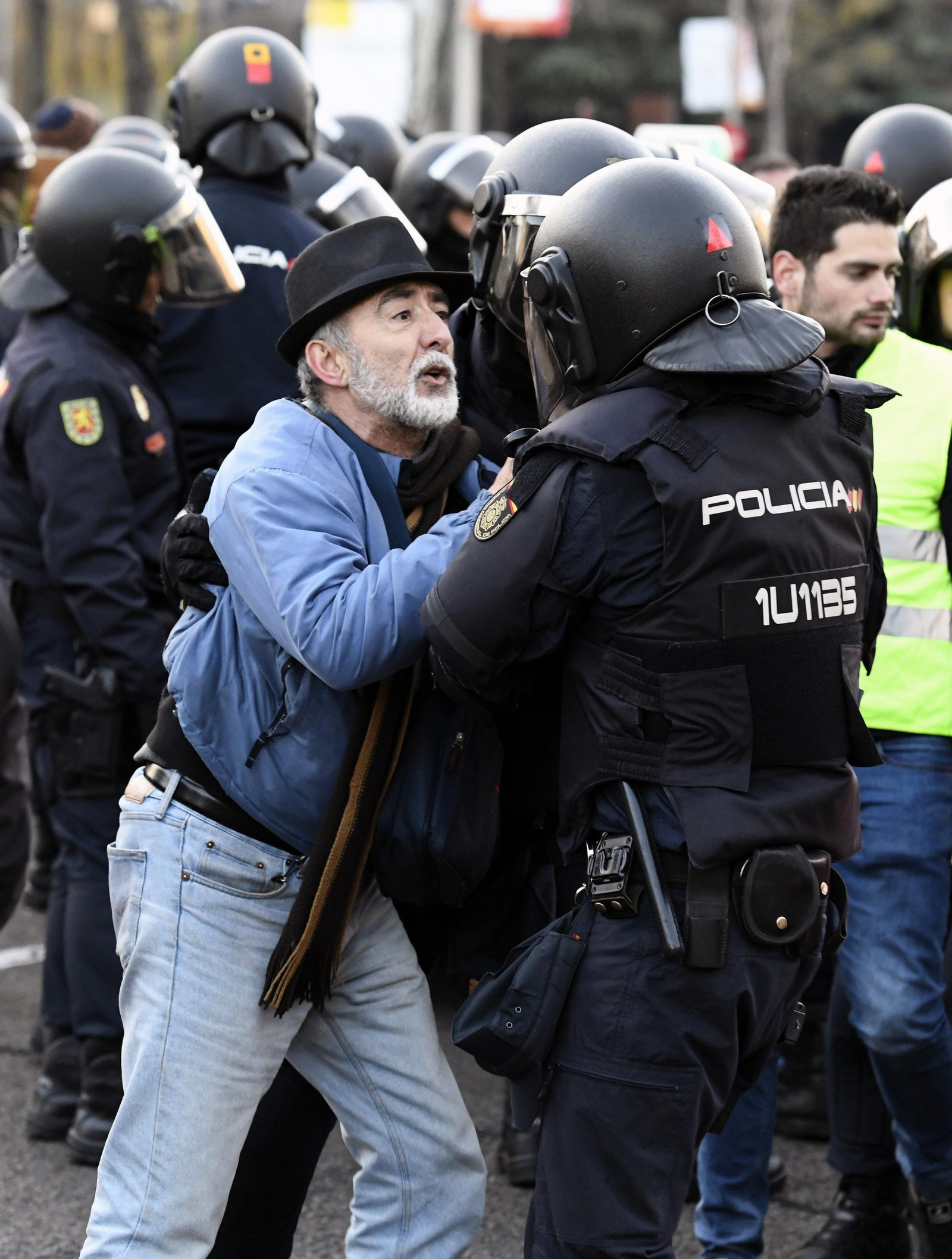 Un taxista recrimina a los agentes de la Policía Nacional que los desalojen de la Castellana.