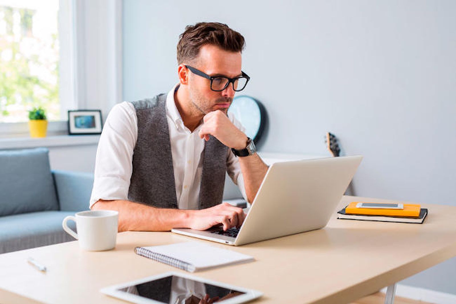Un hombre trabaja con su ordenador desde casa.
