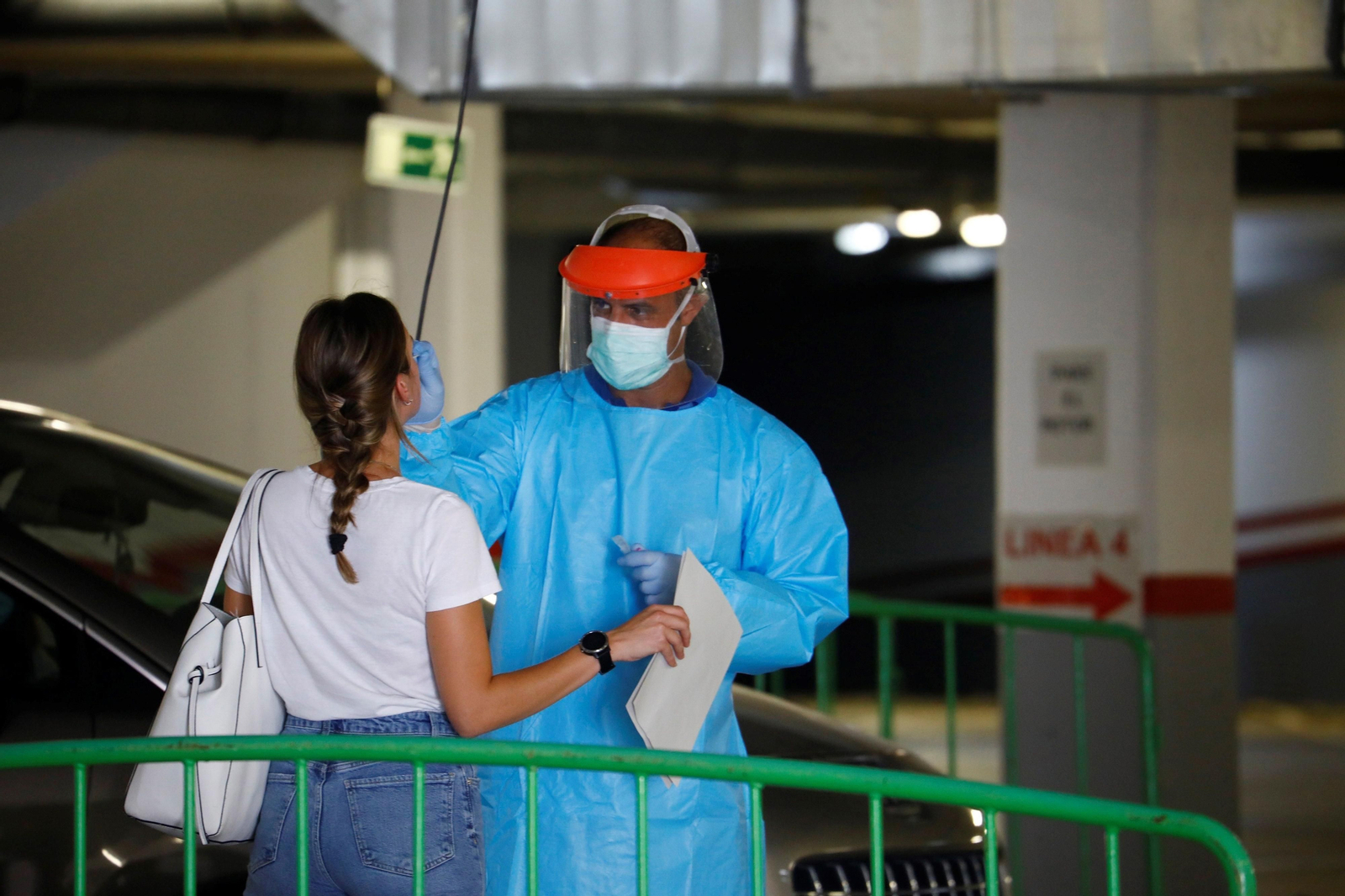 Un profesional sanitario realiza una prueba a una persona en el autocovid de Las Setas.