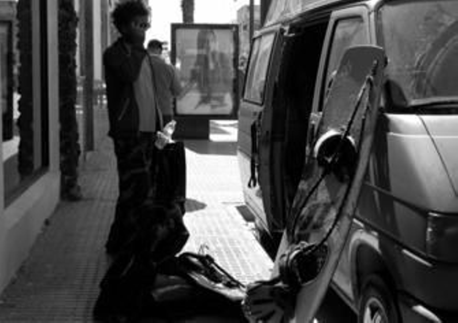 Un joven descarga las tablas de kite de su furgoneta, aparcada en Batalla del Salado.
