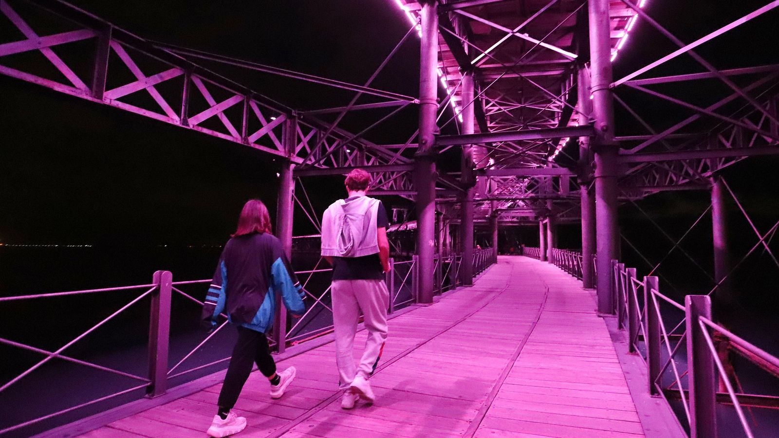 Pasendo en la noche por el muelle con la iluminación colorista.