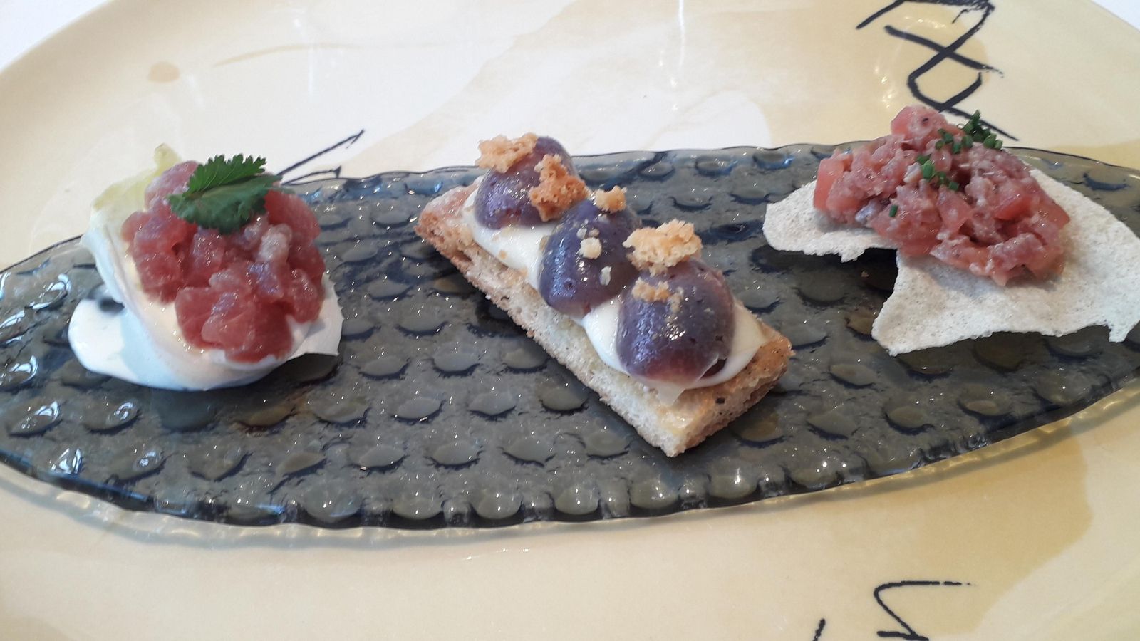 Tartar de salchichón con pan de lentejas; Uvas, pan y queso , y Saam de tartar de atún, el aperitivo del menú 'Tierra'.