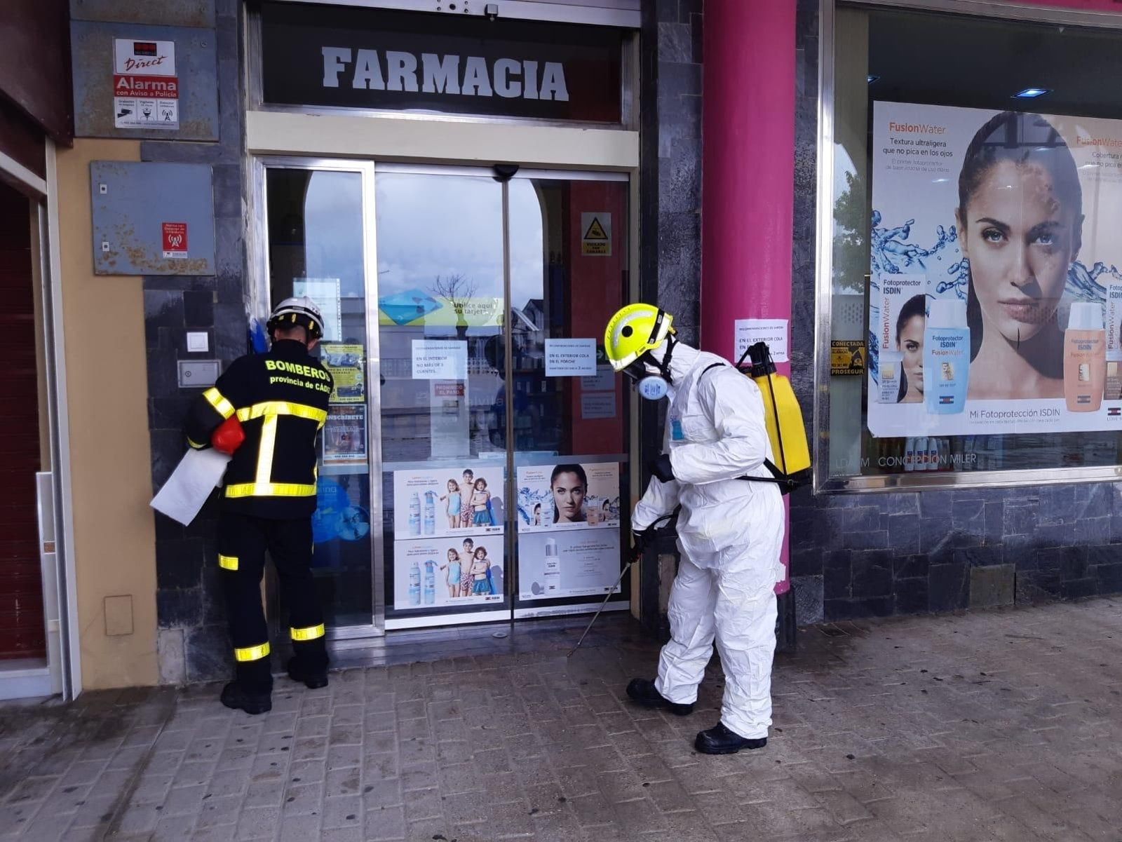 Bomberos desinfectando el acceso a una farmacia en Sanlúcar.