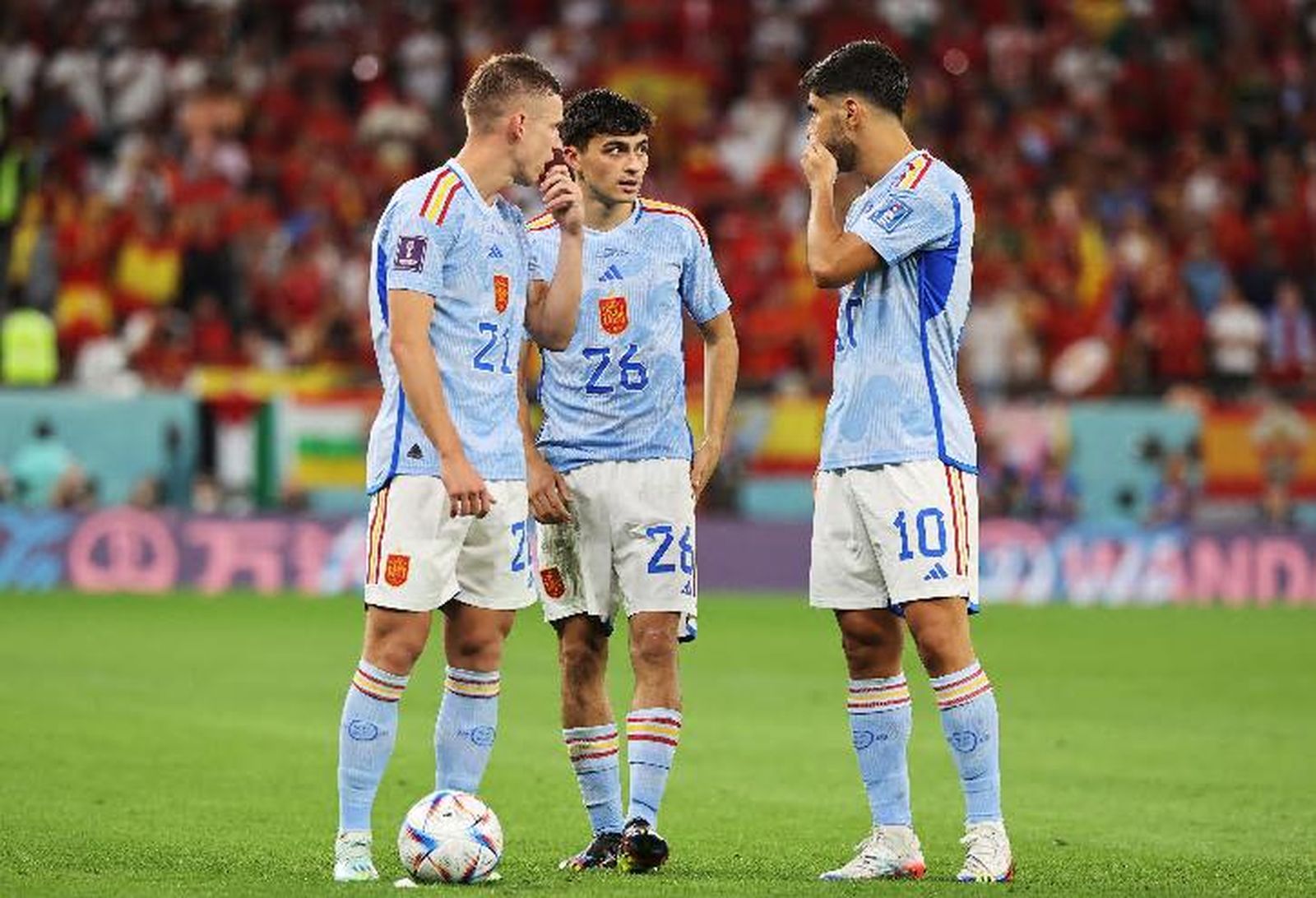 Dani Olmo, Pedri y Asensio intercambian sus pareceres durante un receso del partido.