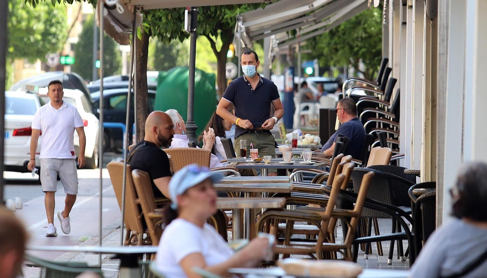 Un camarero atiende una terraza.