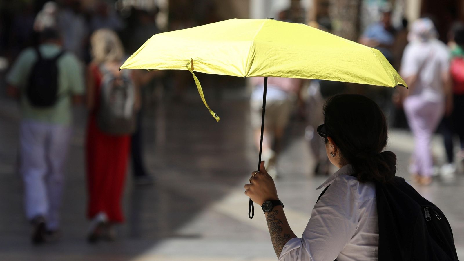 Los paraguas empiezan a ser habituales en Málaga para afrontar el calor.