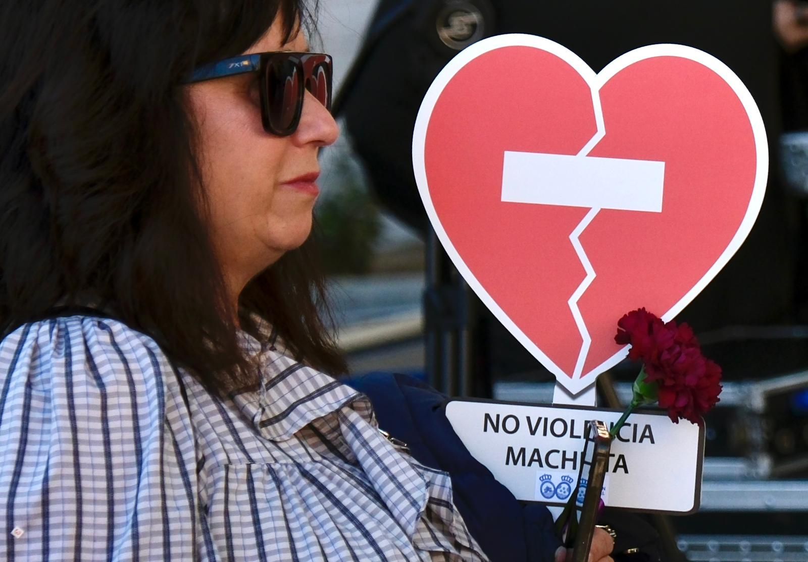 Una mujer sujeta un clavel rojo en la concentración en rechado de la violencia contra la mujeres.