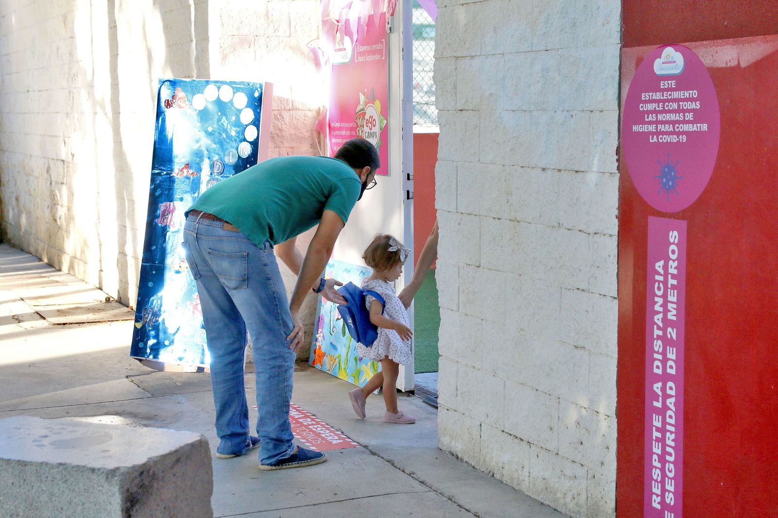 Un padre deja a su hija en el centro de educación en su primer día
