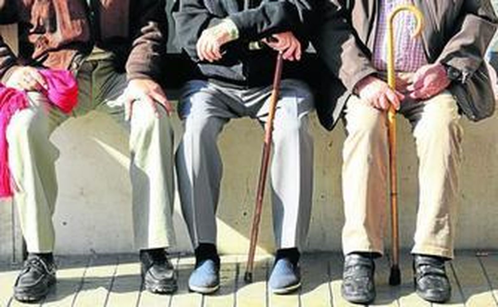 Personas mayores descansan en un banco.