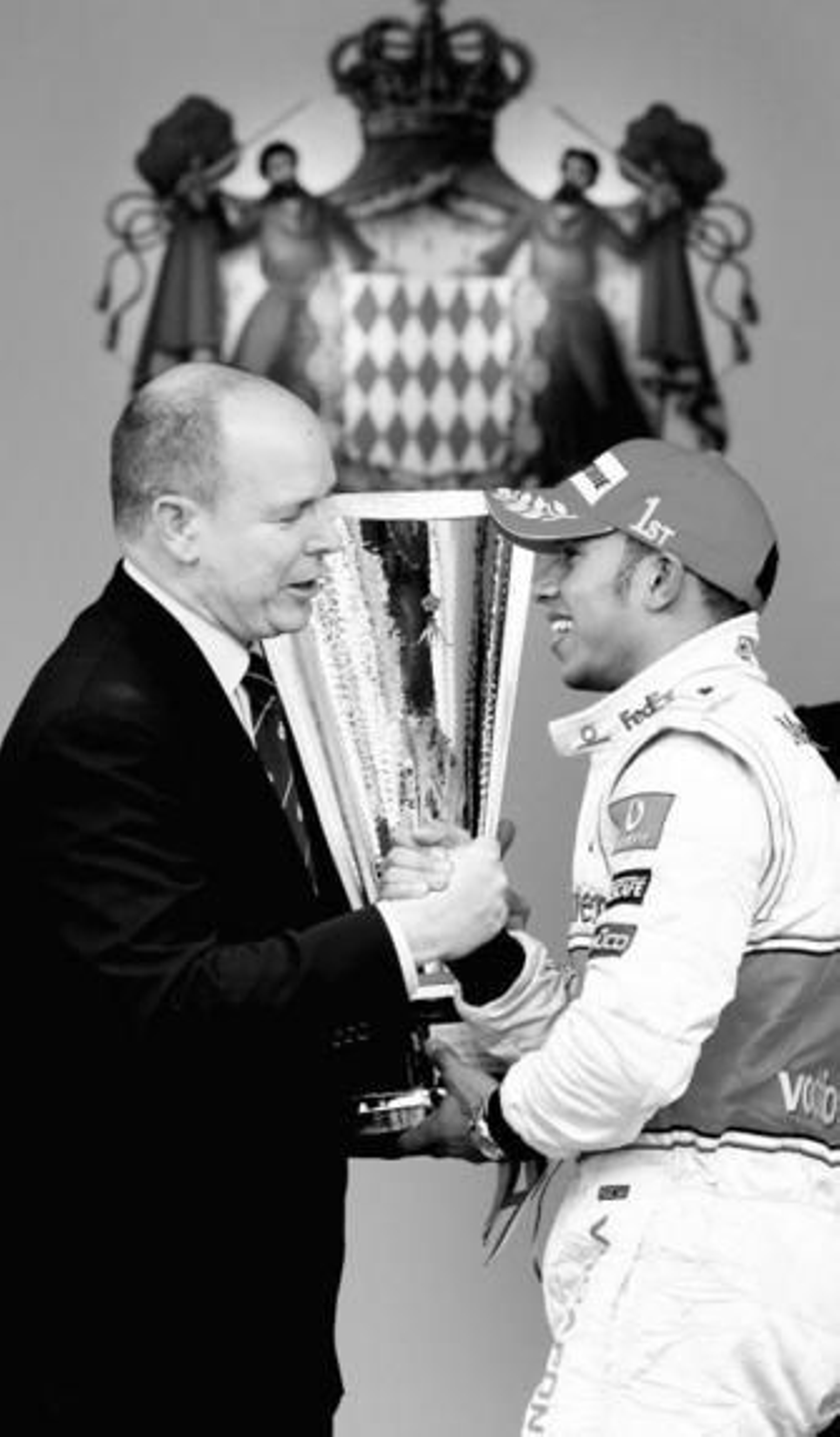 Alberto de Mónaco entrega al británico Lewis Hamilton el trofeo de vencedor en la carrera monegasca.