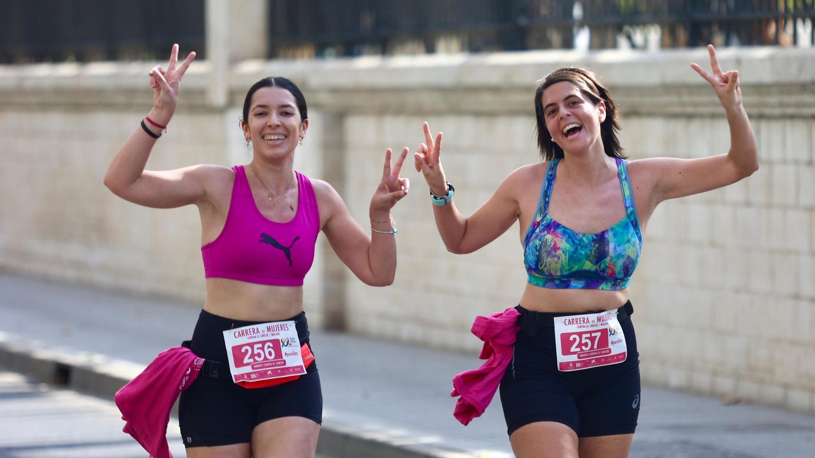 Dos de las corredoras saludan al pasar por el Paseo de los Curas.