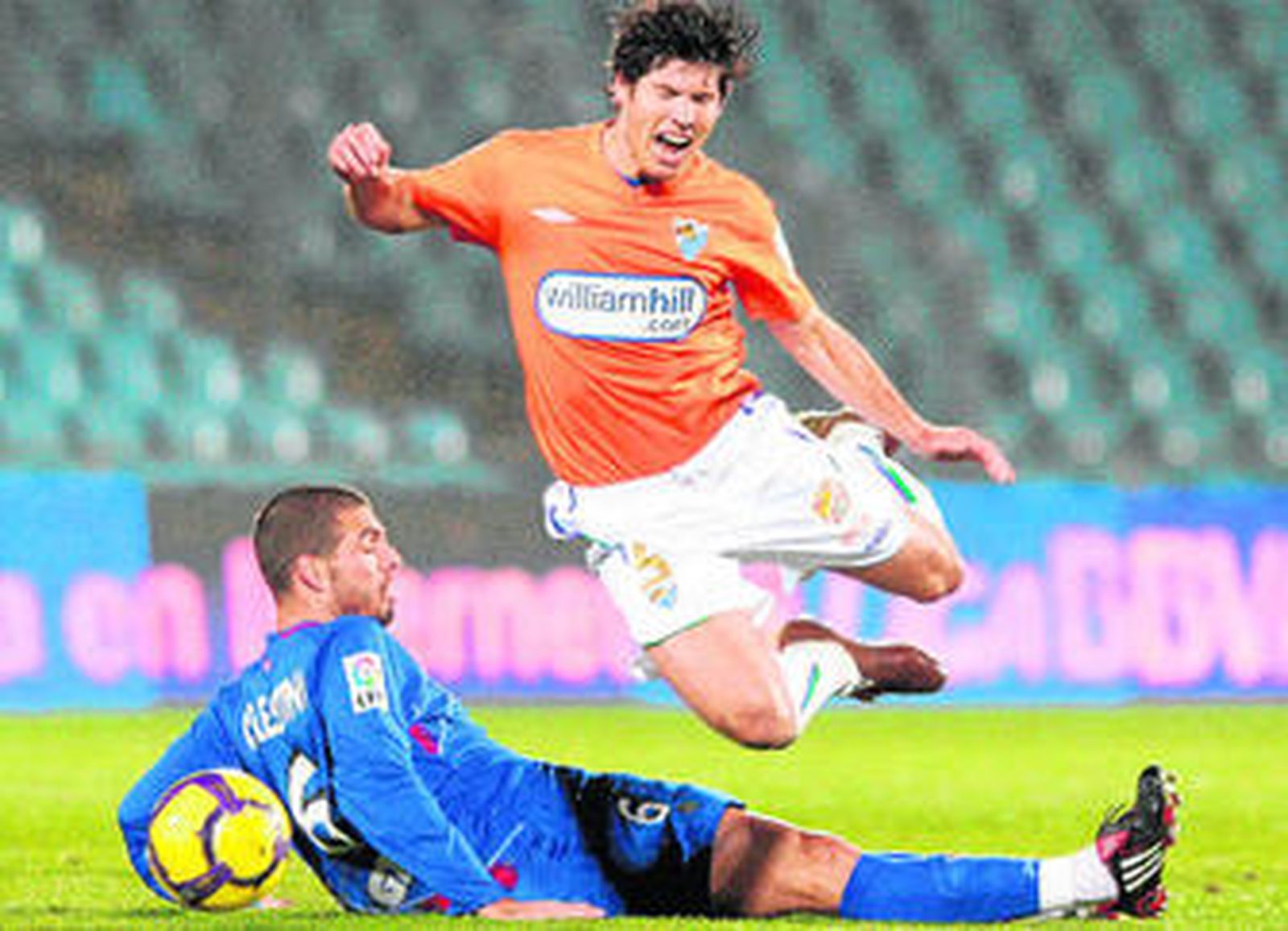 Luque intenta superar una entrada a ras de césped de Celestini.