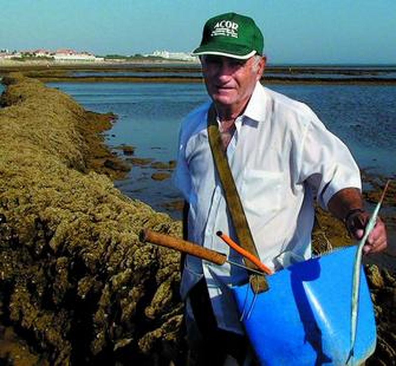 Severiano Medina sostiene una aguja capturada en los corrales de Rota. Al fondo, la Villa roteña.
