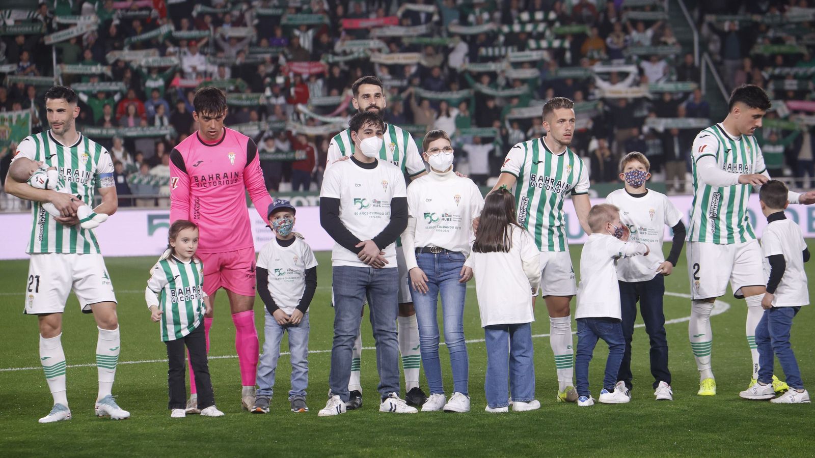 Los jugadores del Córdoba CF, acompañados por niños que pasaron por el Reina Sofía.